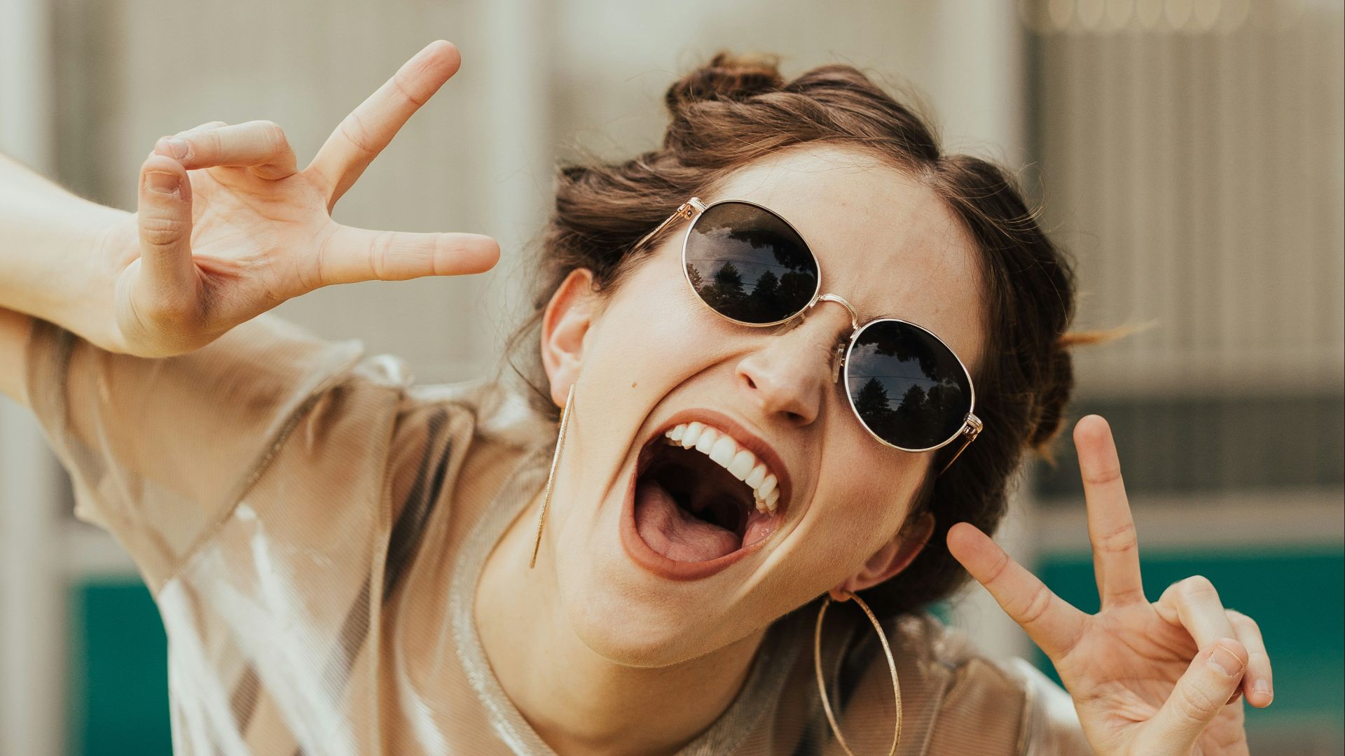 selective focus photography of jolly woman using peace hand gesture