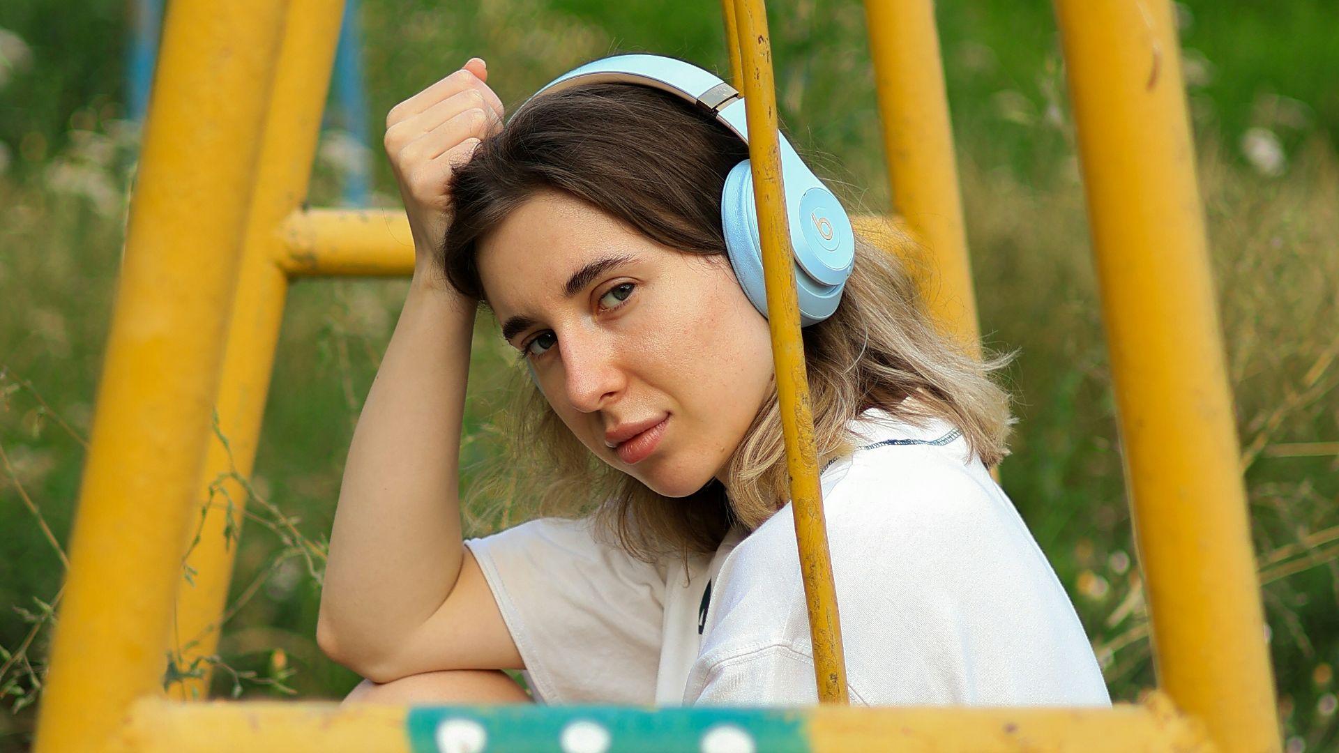 a woman sitting on a swing in a park