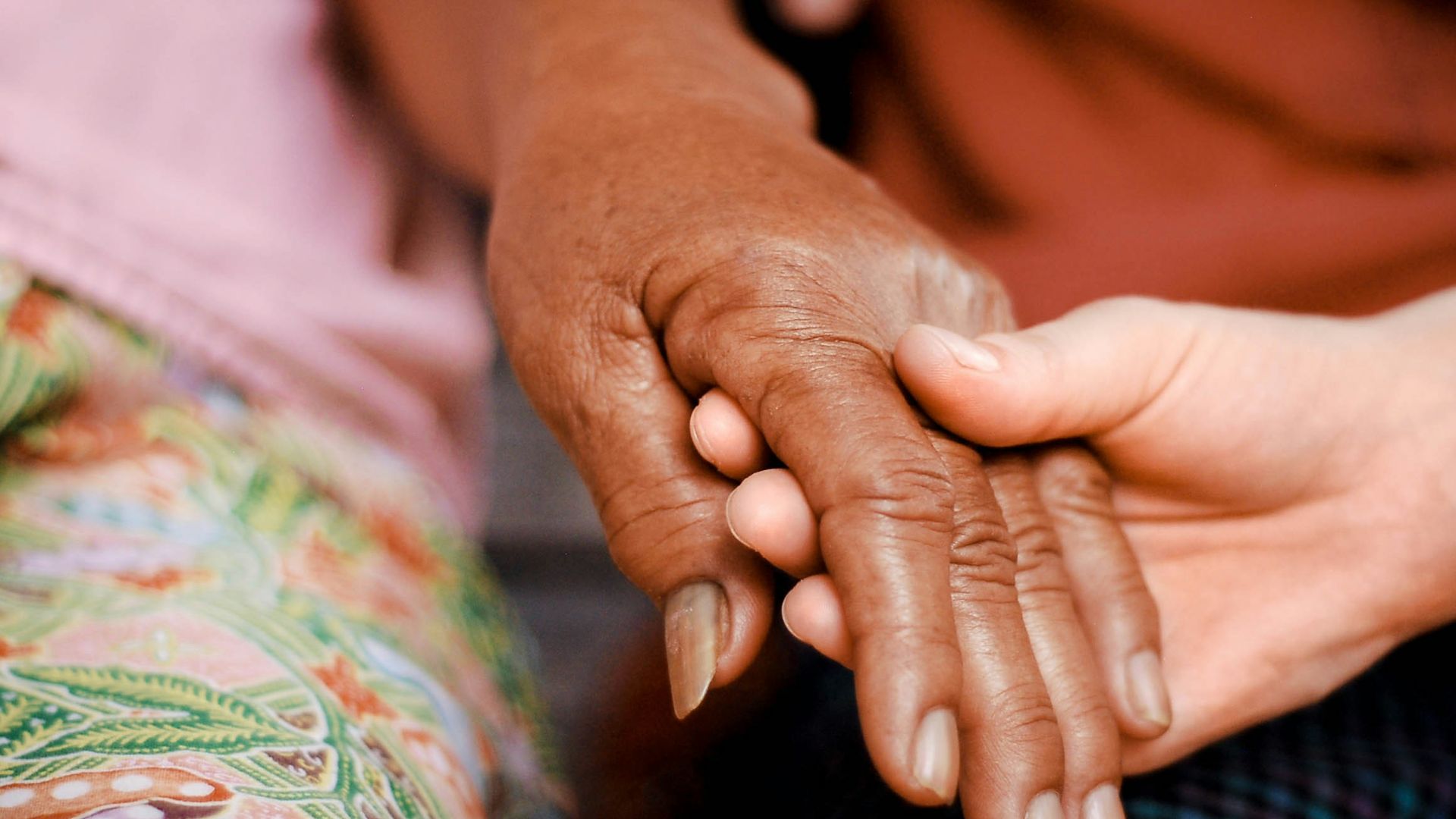 a close up of two people holding hands