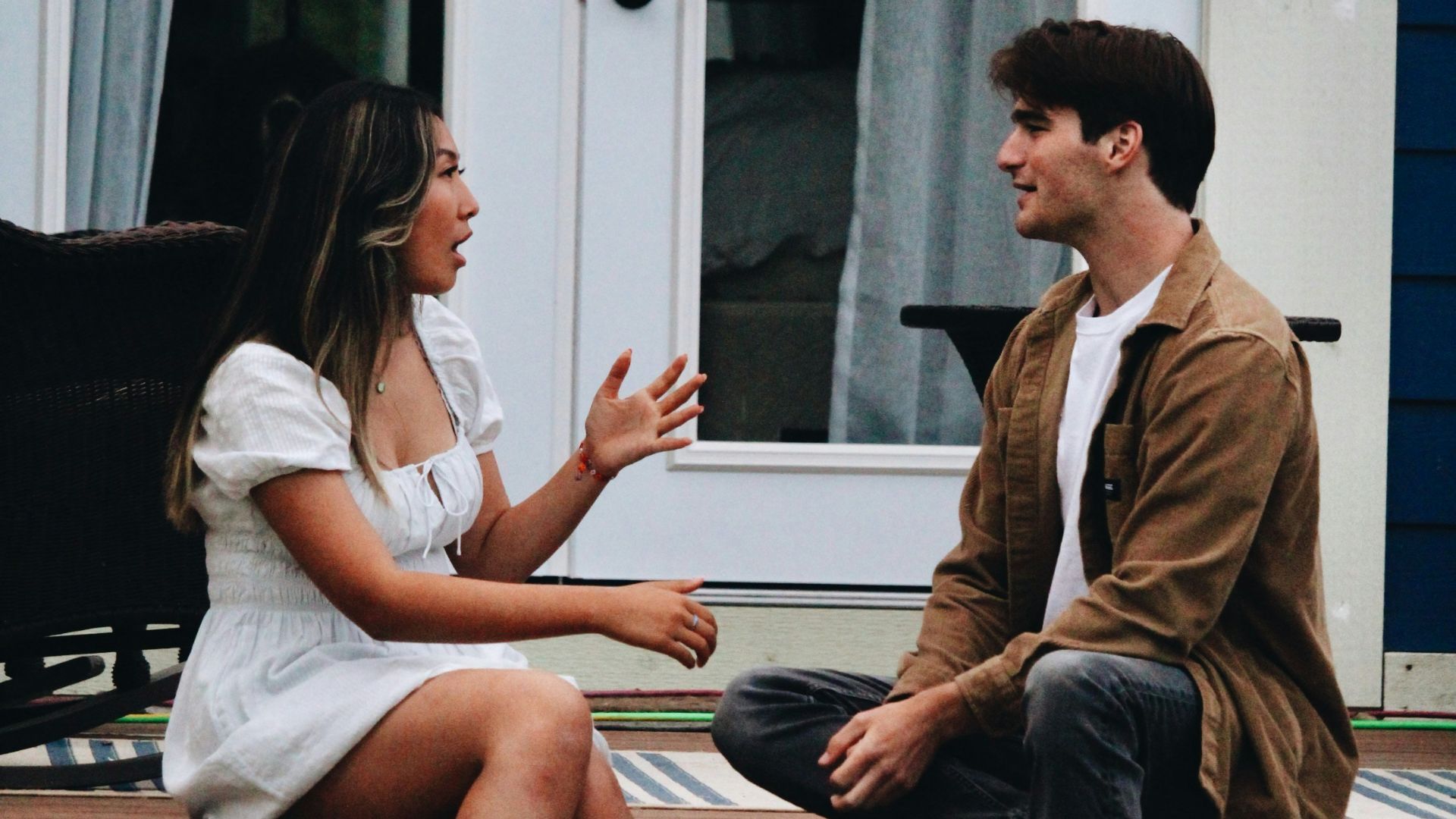 a man and woman sitting on a porch