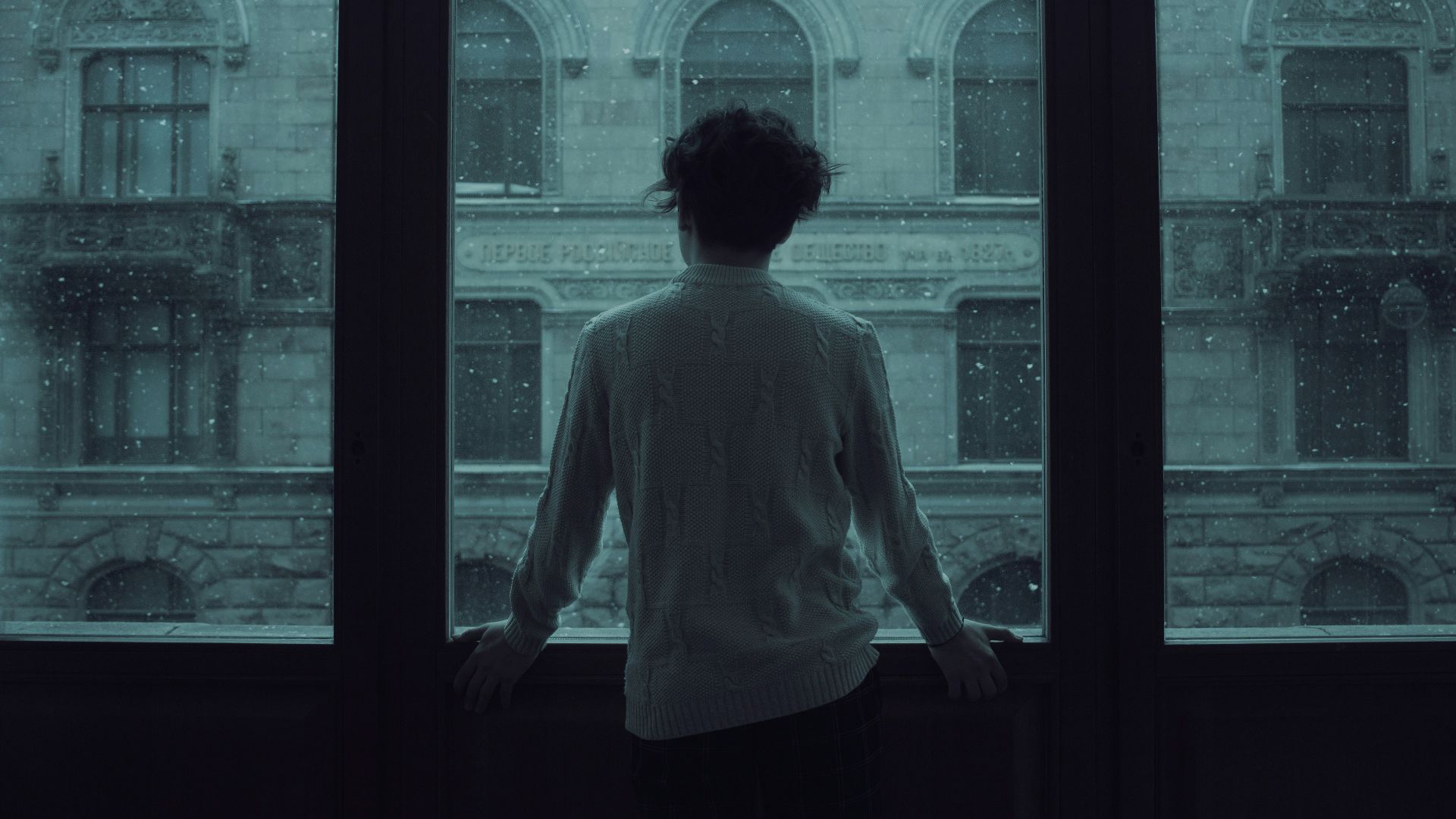 woman in white shirt standing in front of window