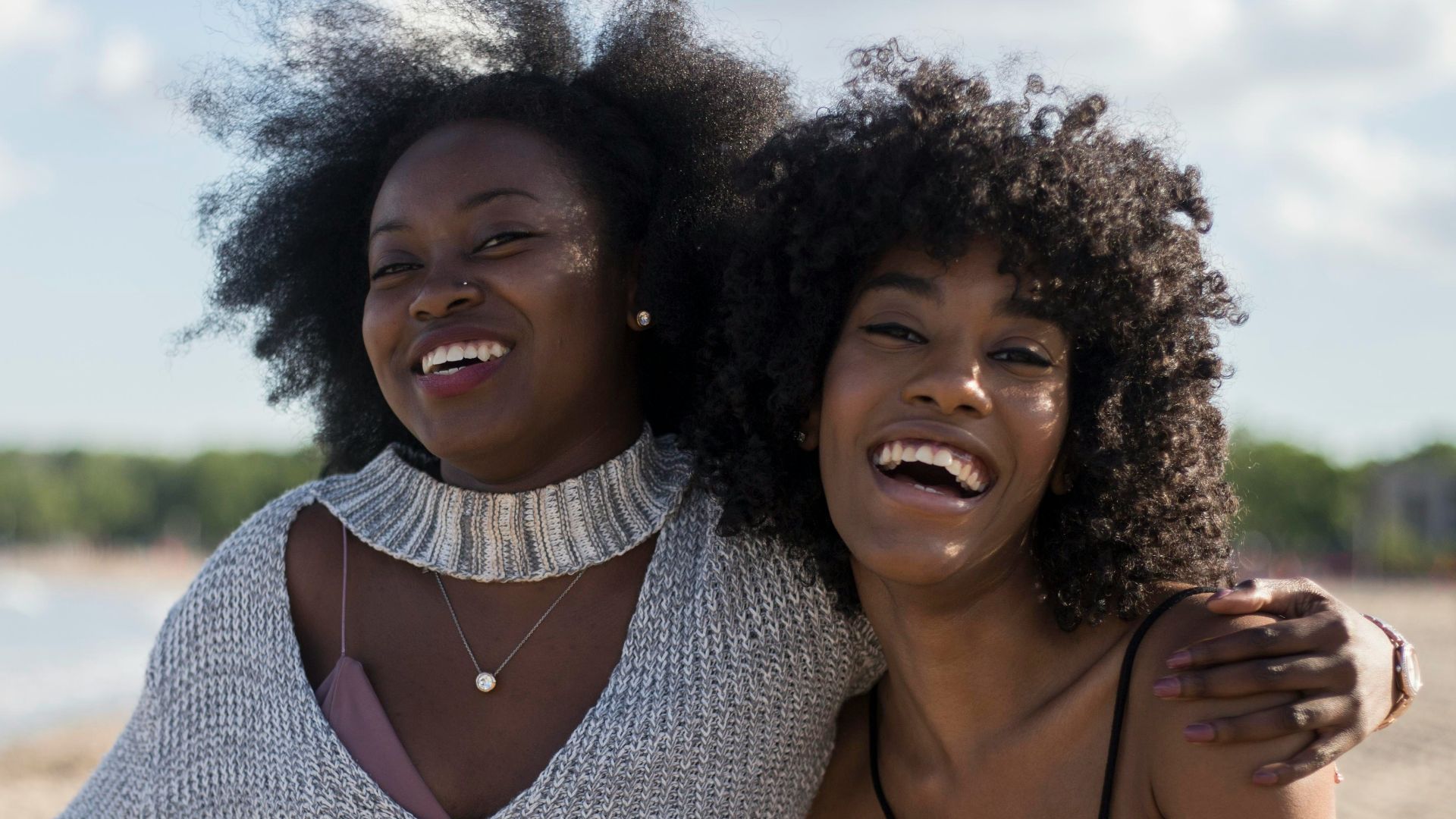 photo of woman beside another woman at seashore