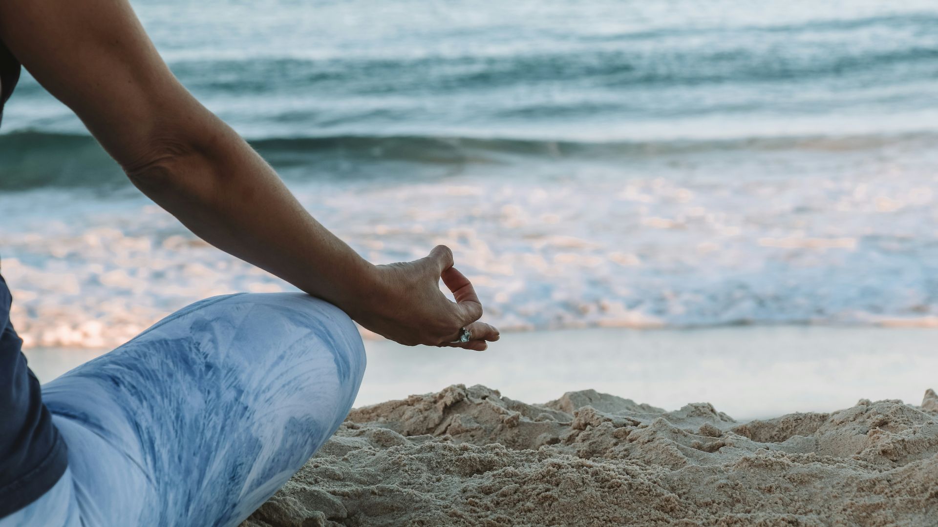 person in blue shorts sitting on beach shore during daytime