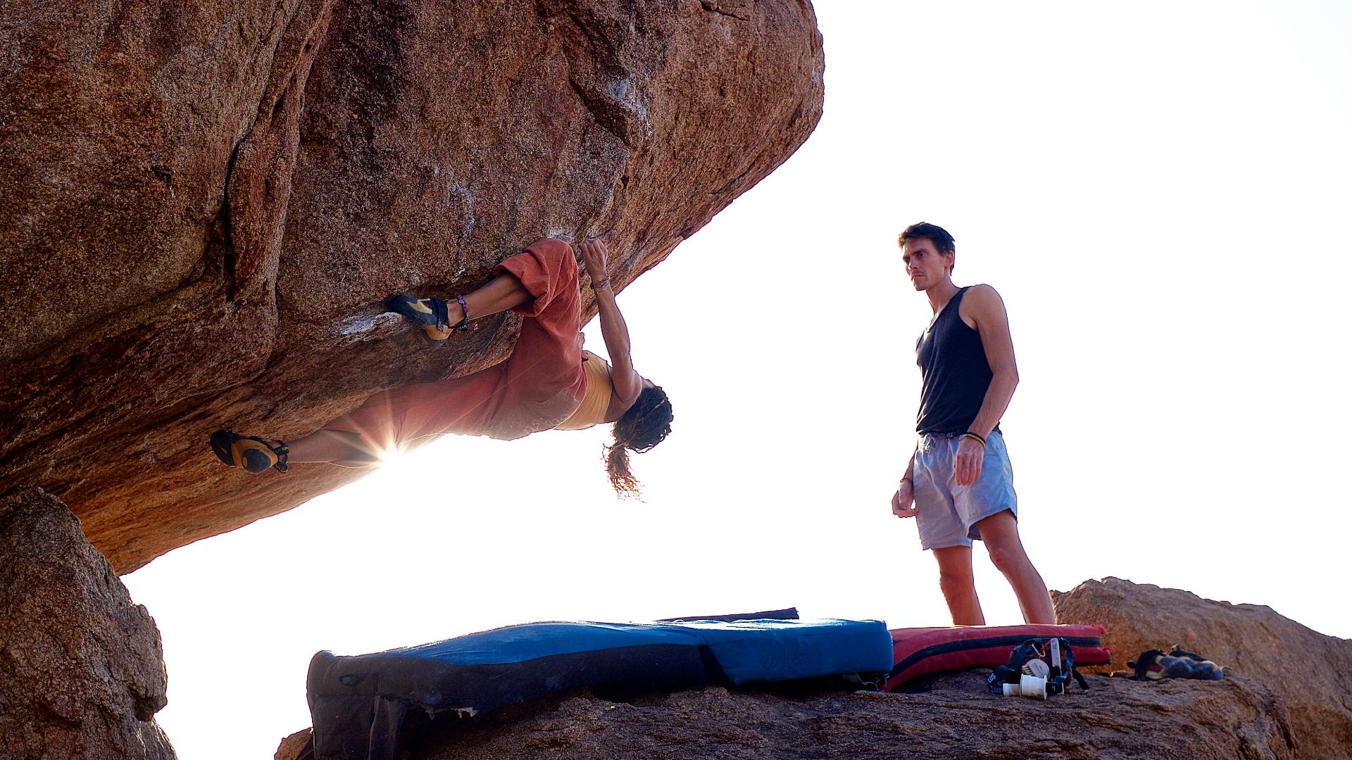 a man standing on top of a rock next to another man