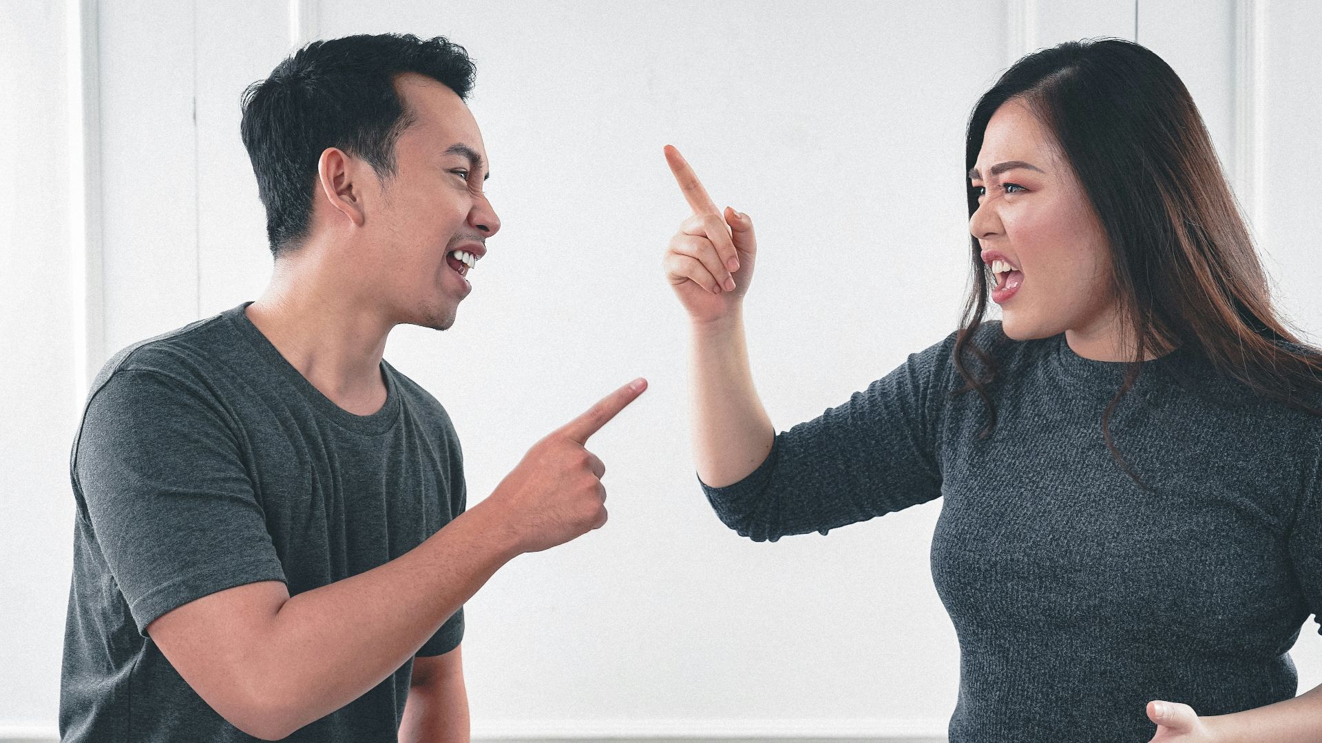 man in gray crew neck long sleeve shirt standing beside woman in black crew neck shirt