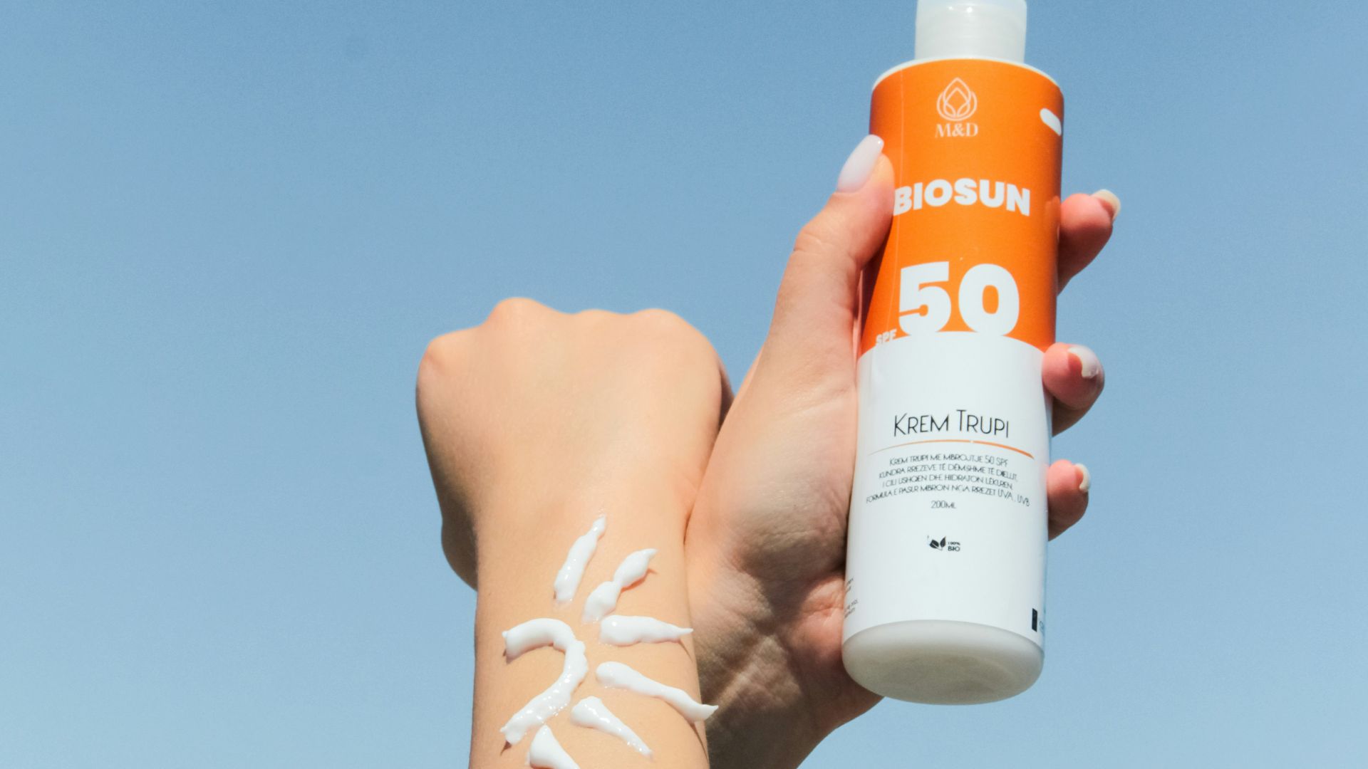 a person holding a bottle of sunscreen in their hand