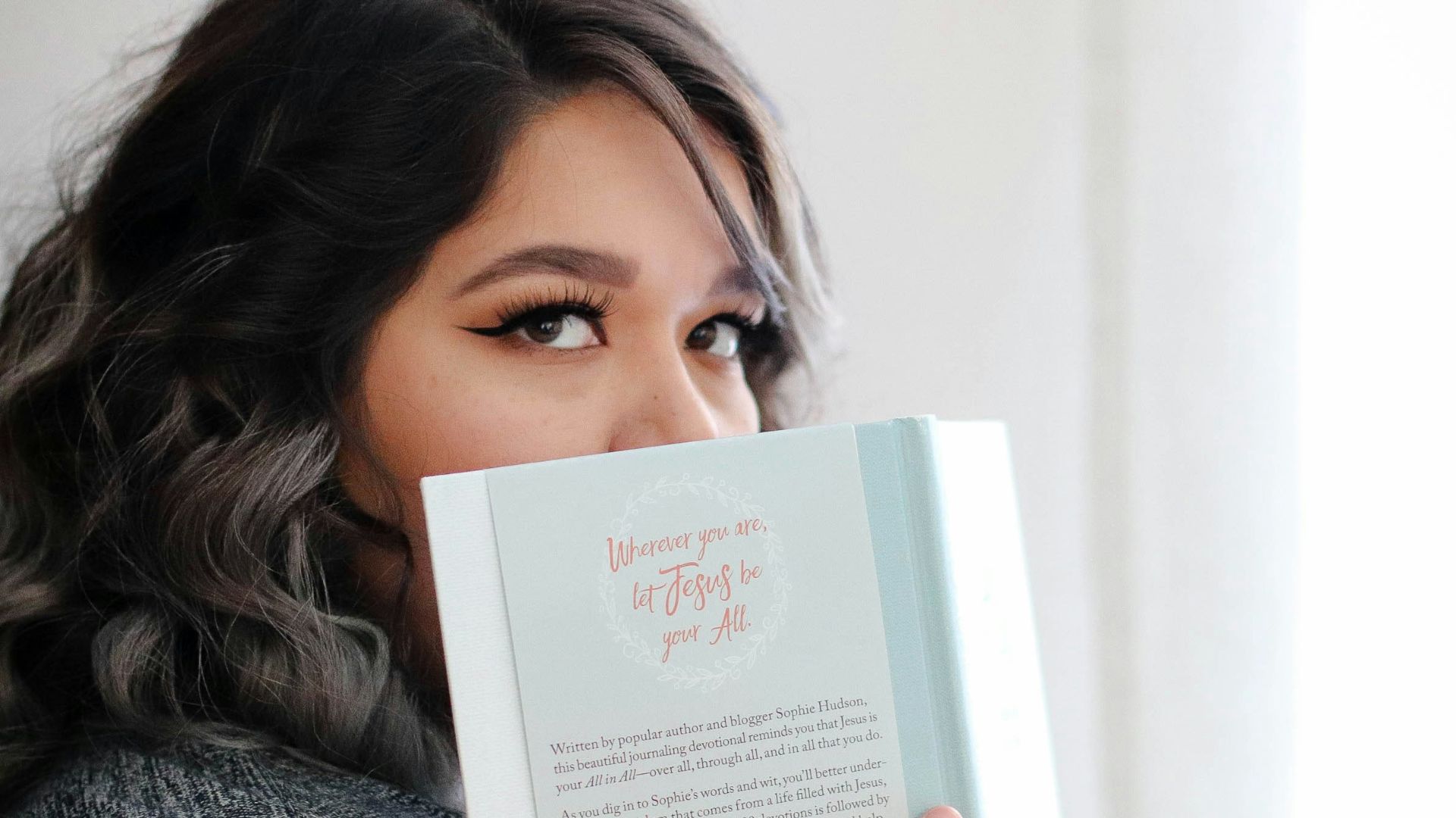 woman covering her face with book