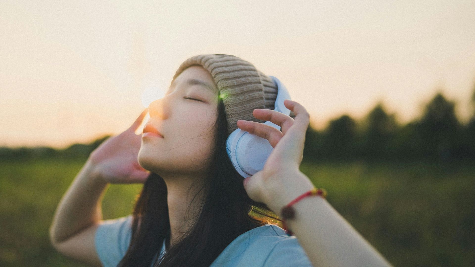 a woman in a field with a cell phone to her ear