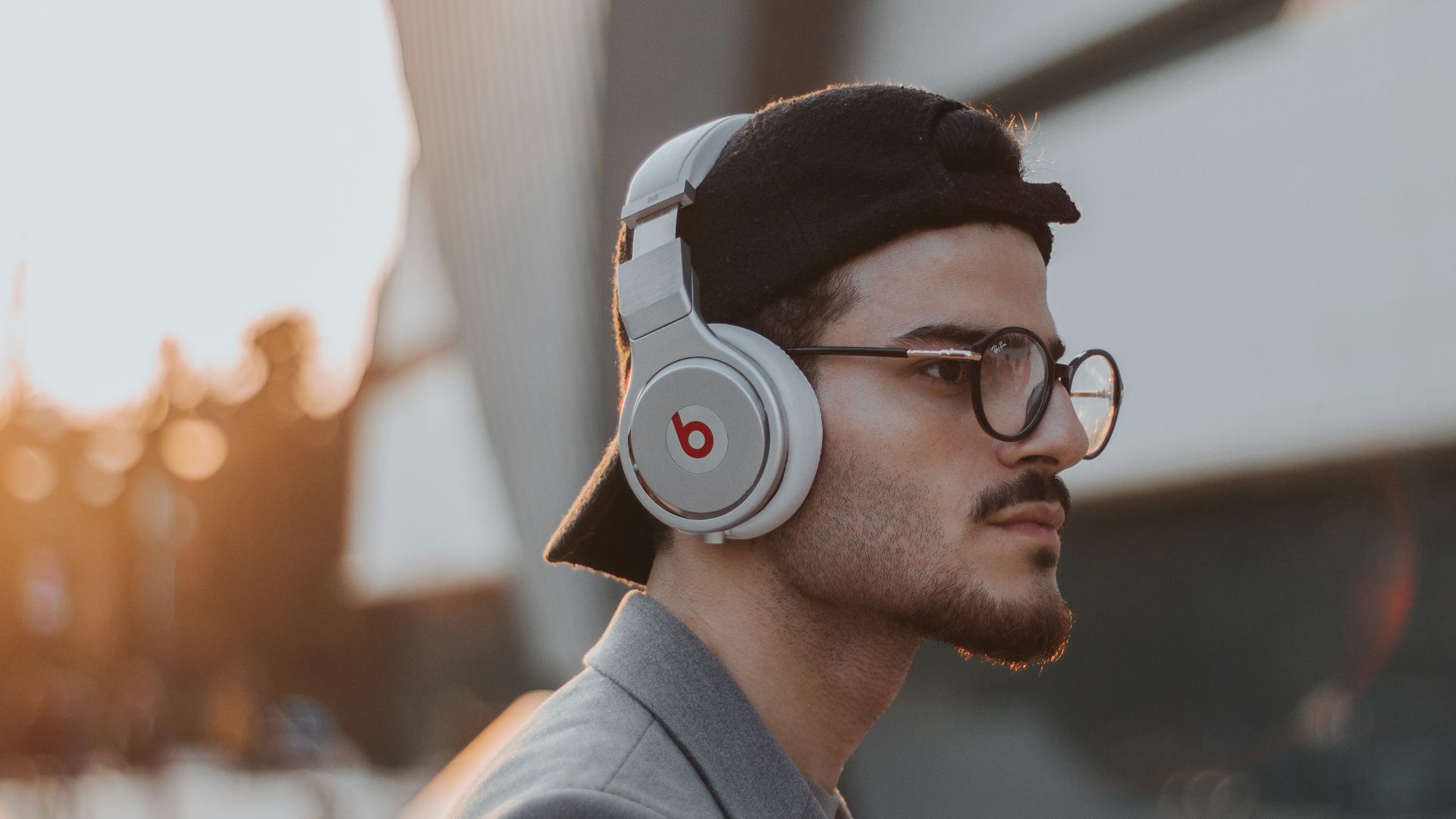 shallow focus photography of man wearing Beats wireless headphones