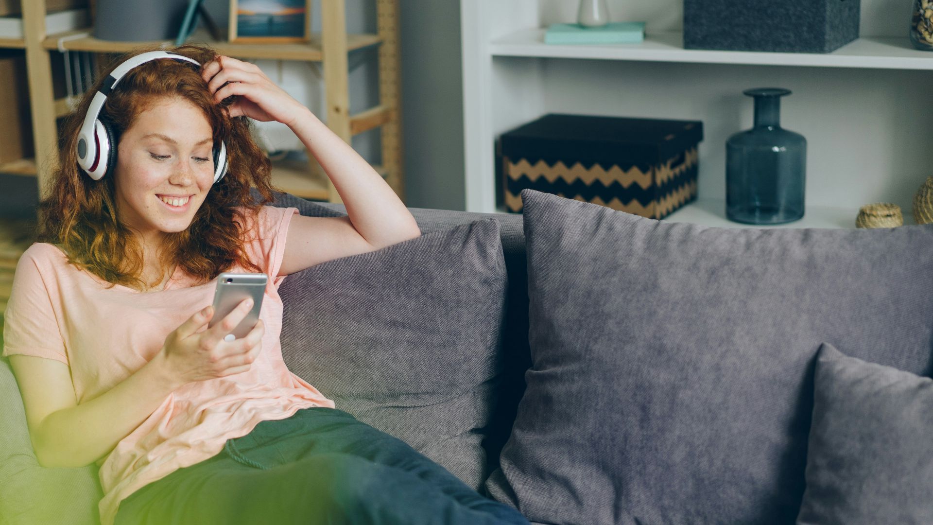 a woman sitting on a couch listening to music