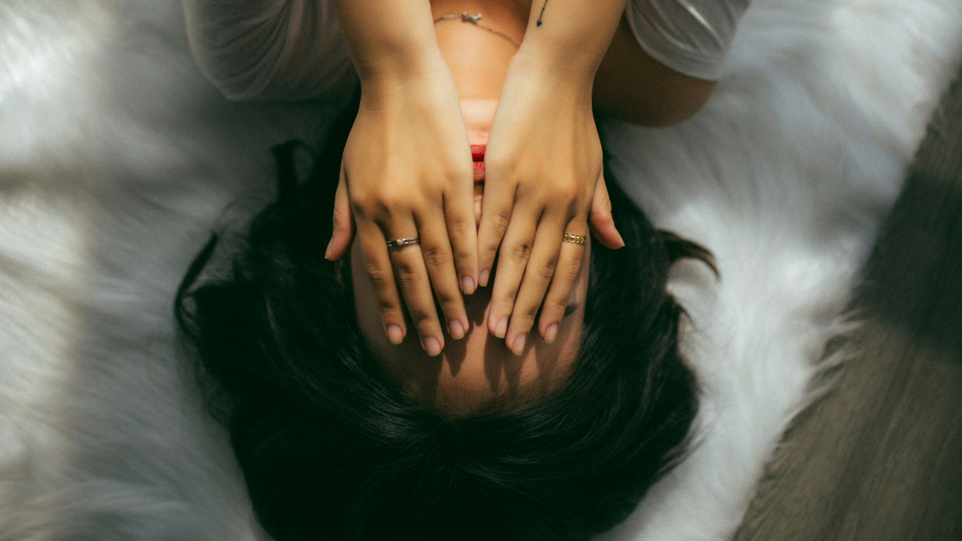 a woman holds her hands over her face