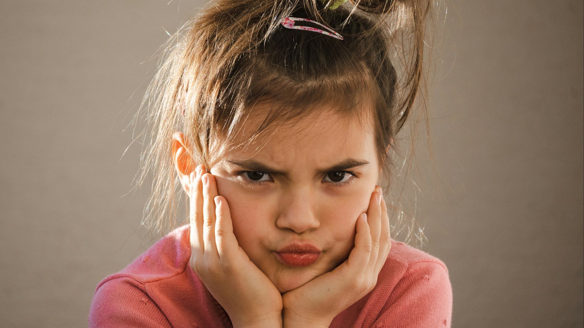 a young girl with her hands on her face