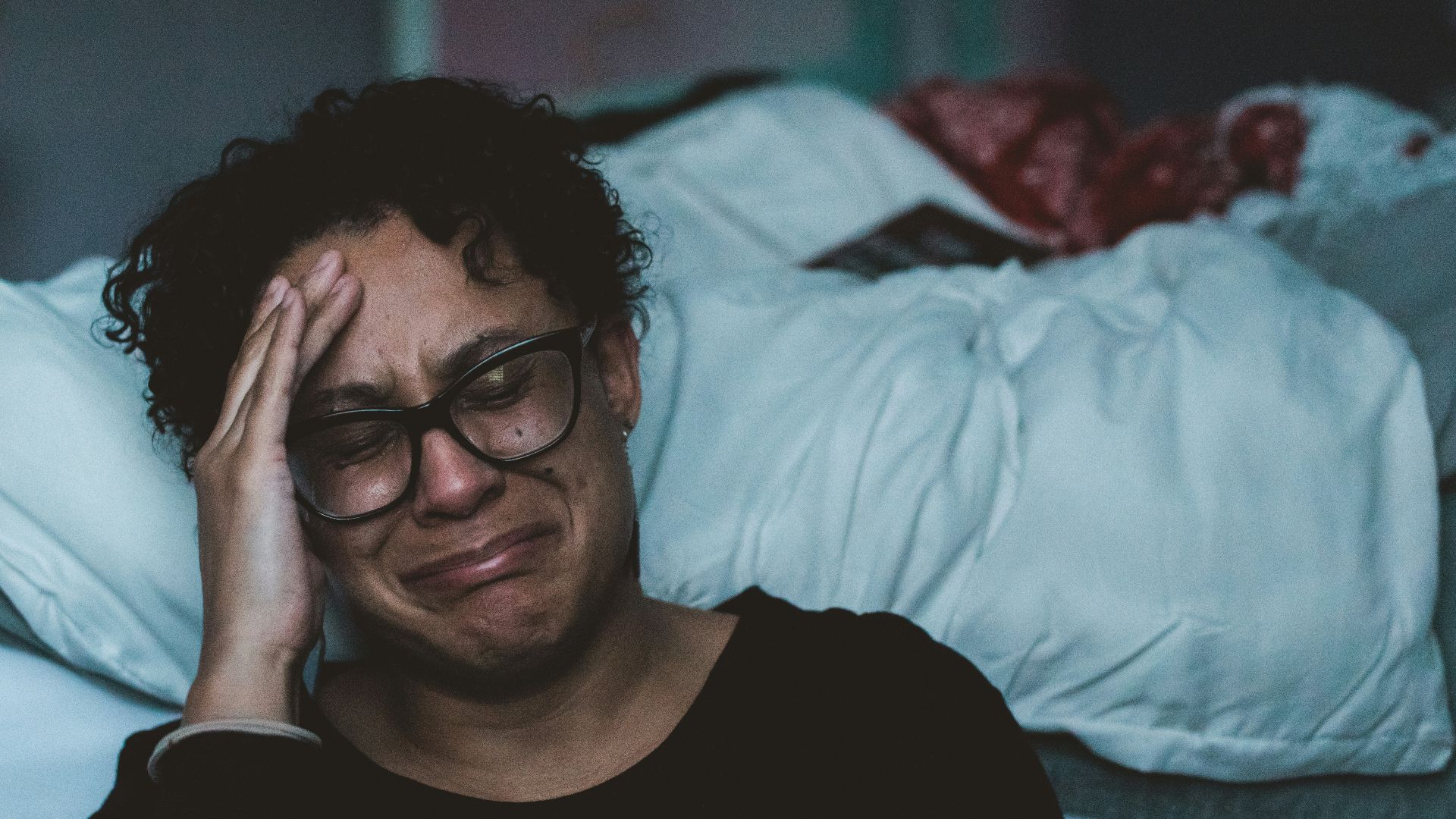 person crying beside bed