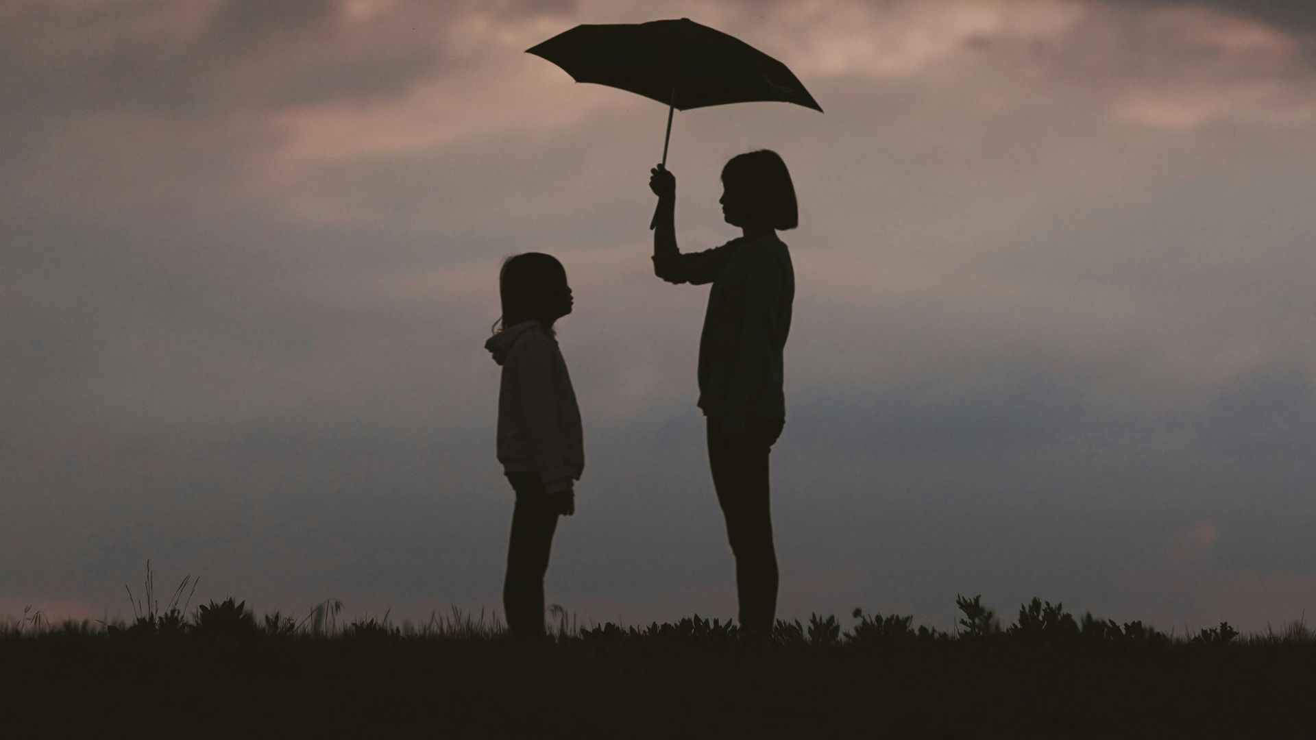 girl holding umbrella on grass field