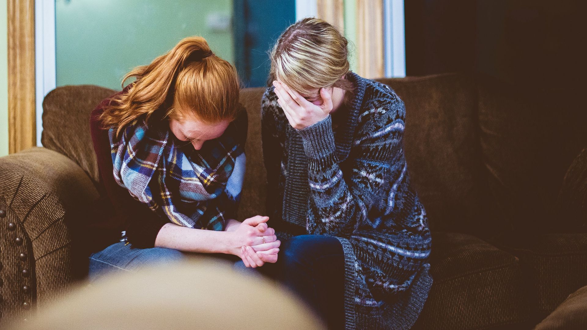 man and woman sitting on sofa in a room