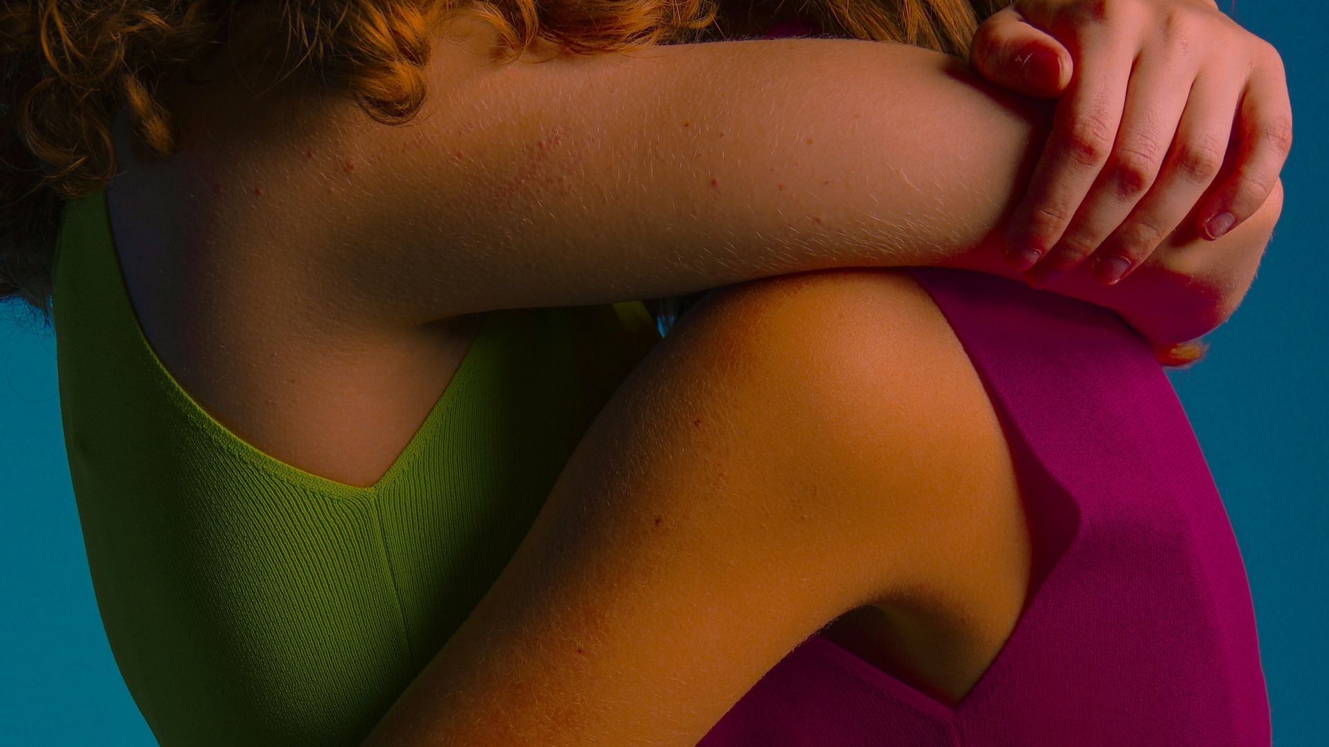 a couple of women hugging each other with a blue background