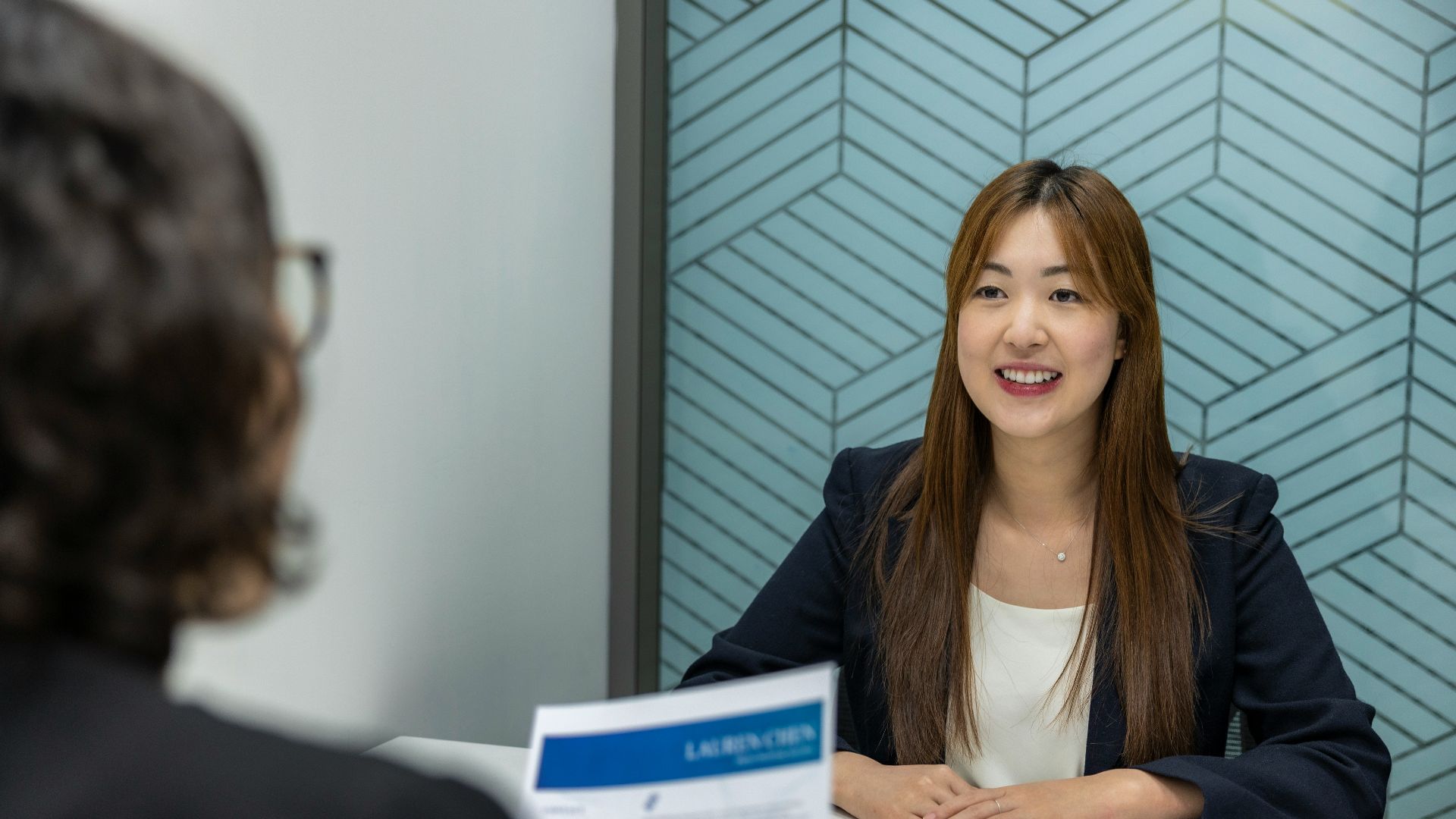 a woman sitting at a table with a piece of paper in front of her