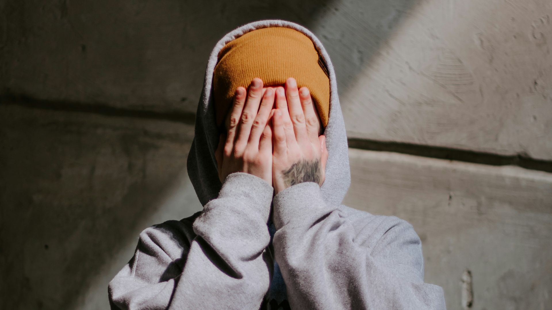 person in gray hoodie wearing brown leather shoes