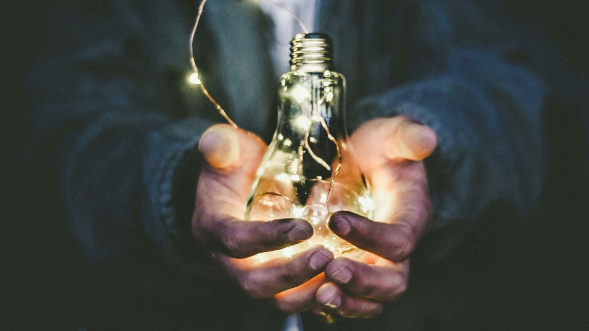 man holding incandescent bulb