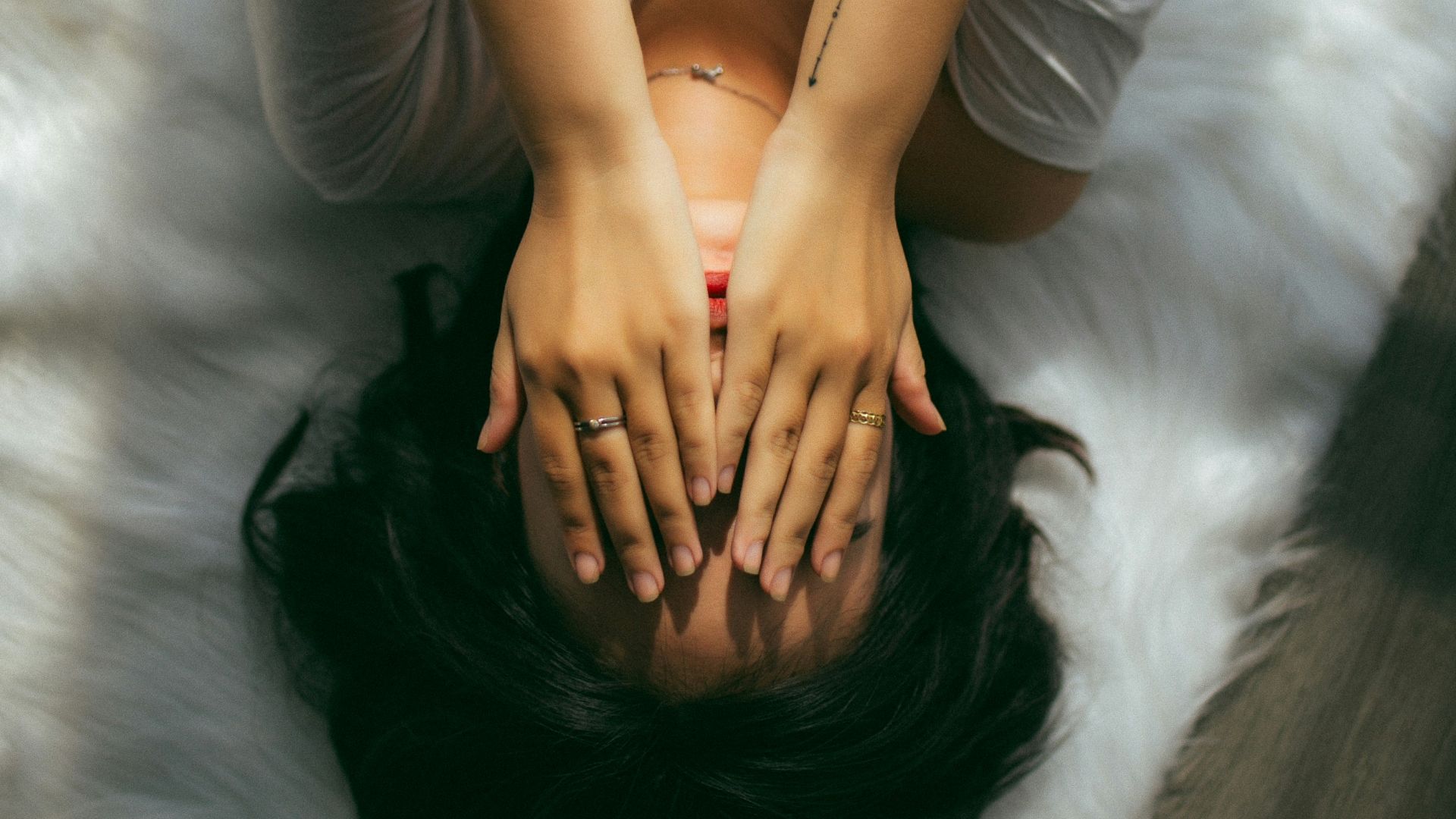 a woman holds her hands over her face