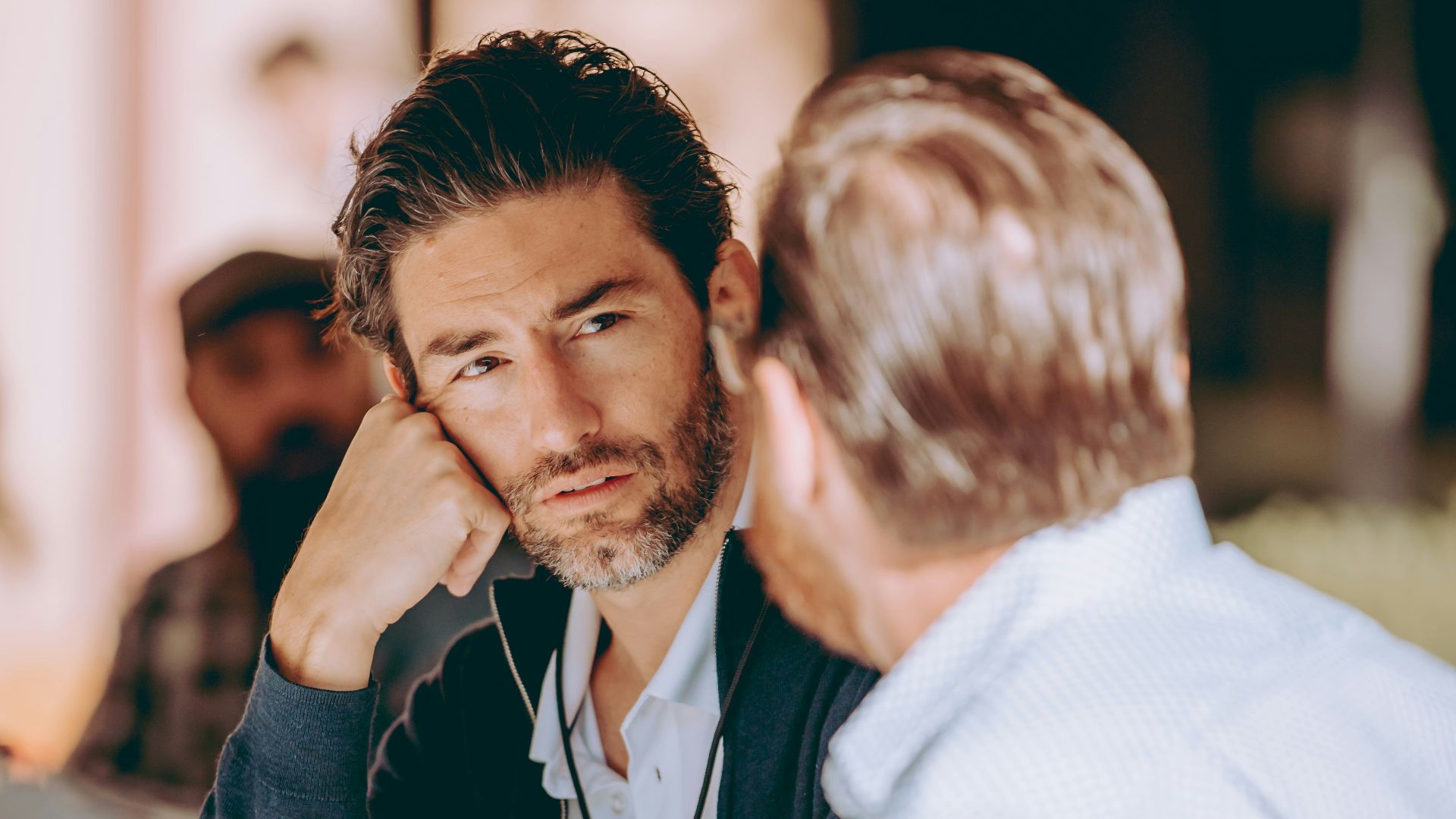 two men sitting at a table talking to each other