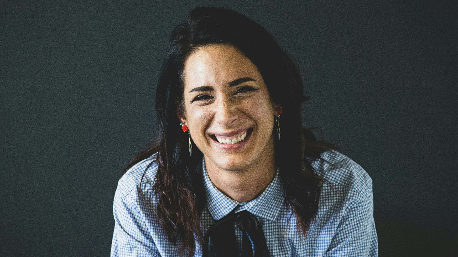 smiling woman in white and black checkered dress shirt