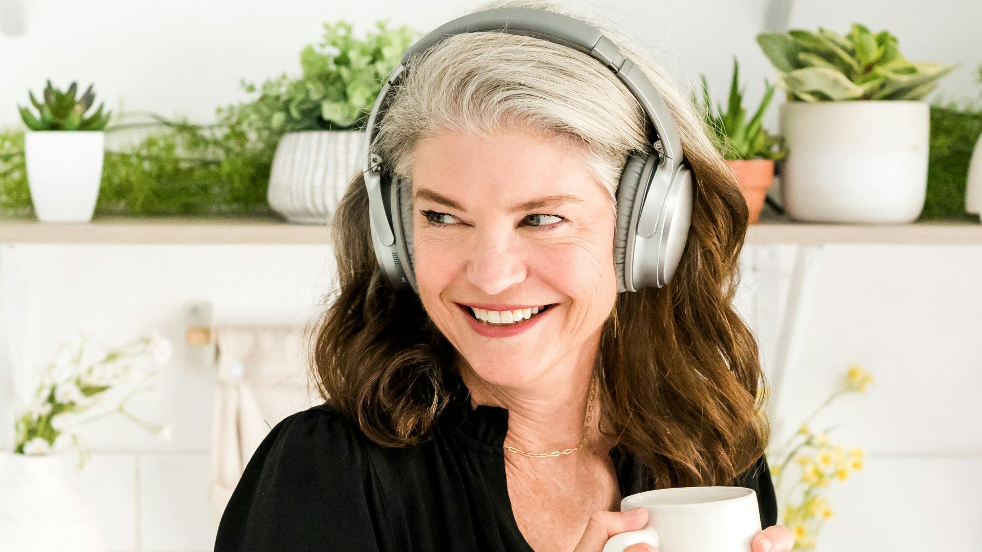 a woman wearing headphones and holding a cup