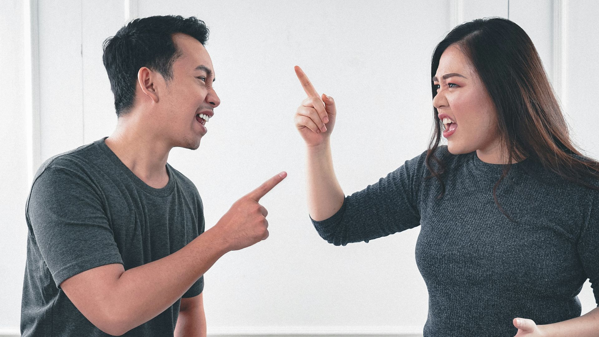 man in gray crew neck long sleeve shirt standing beside woman in black crew neck shirt