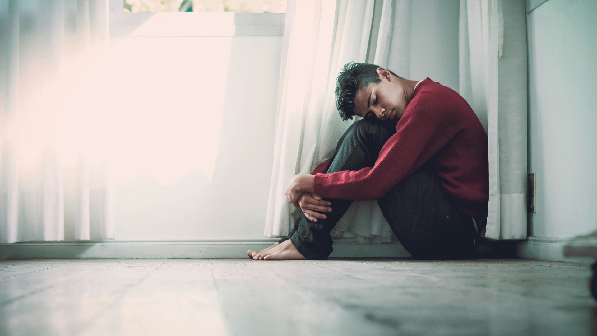 man beside white frame window