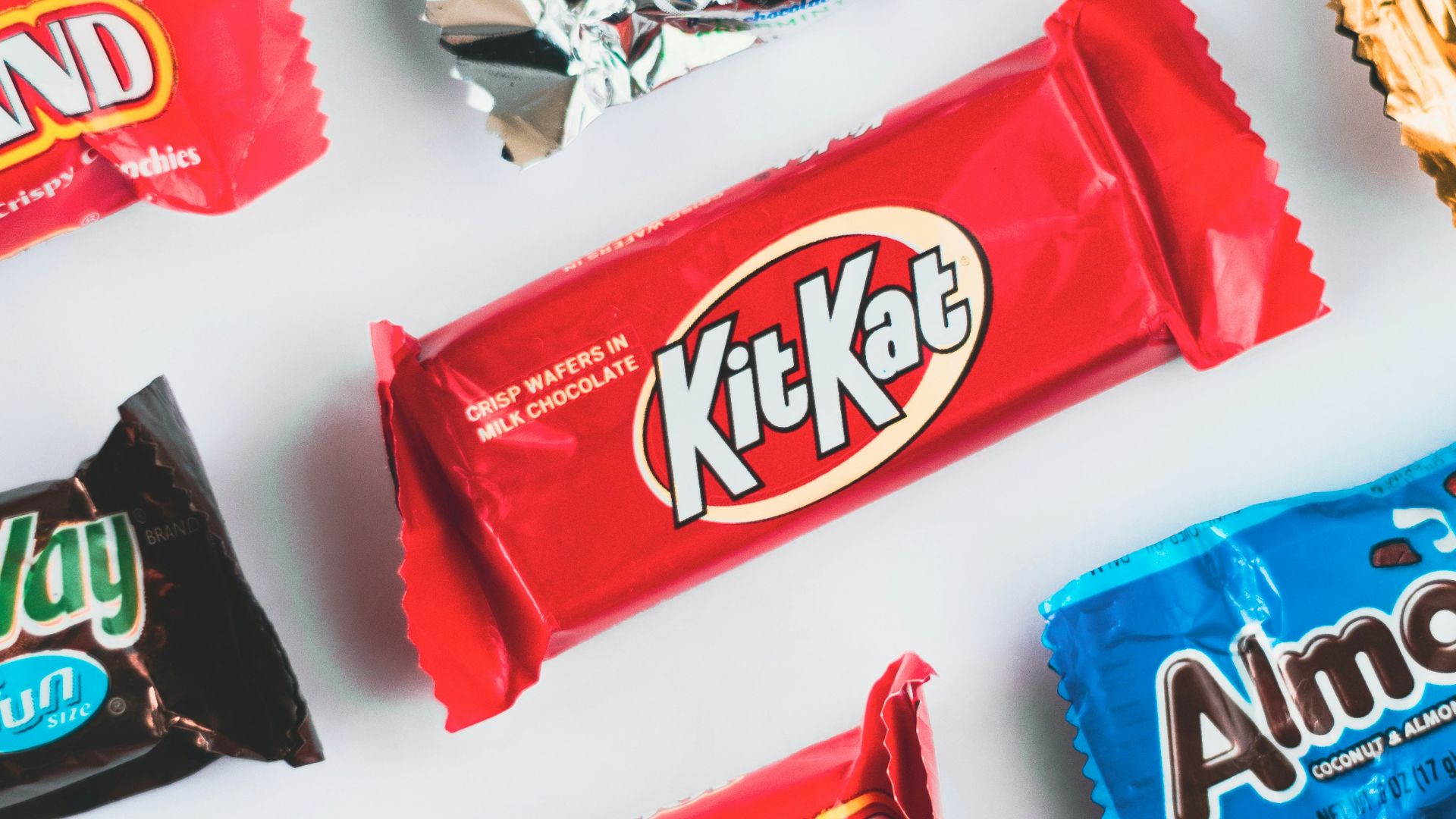 a variety of candy bars lined up on a white surface