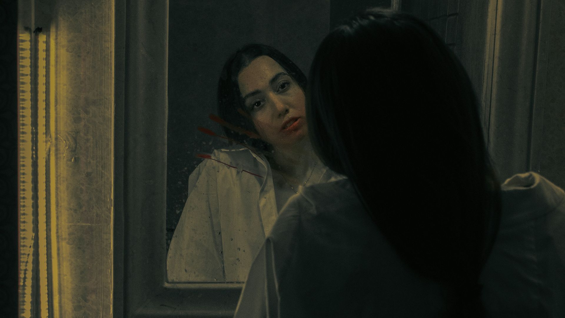 a woman standing in front of a bathroom mirror