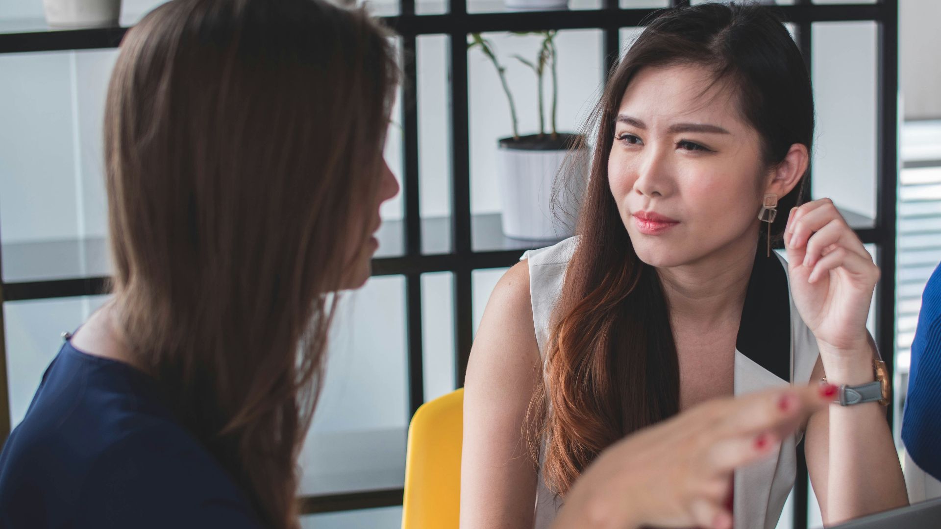 woman sitting on yellow armless chair near gray laptop computer