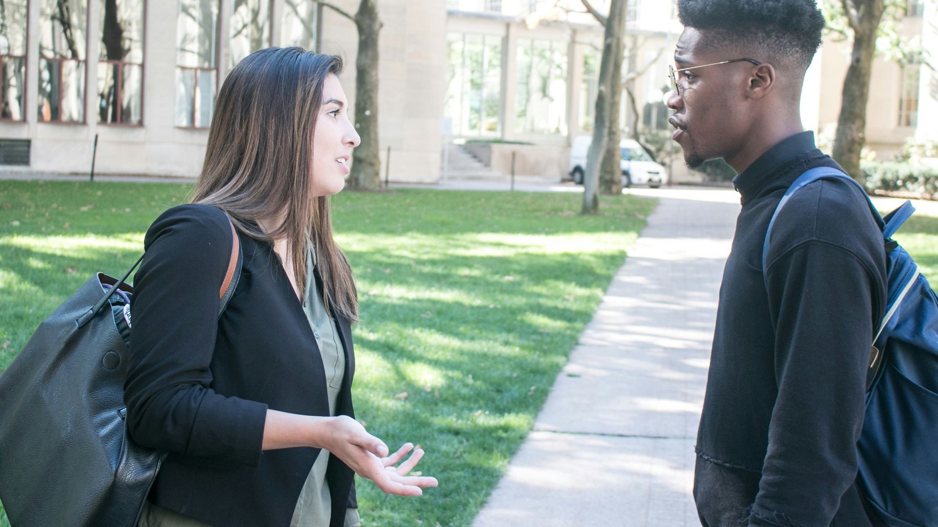 a man standing next to a woman on a sidewalk