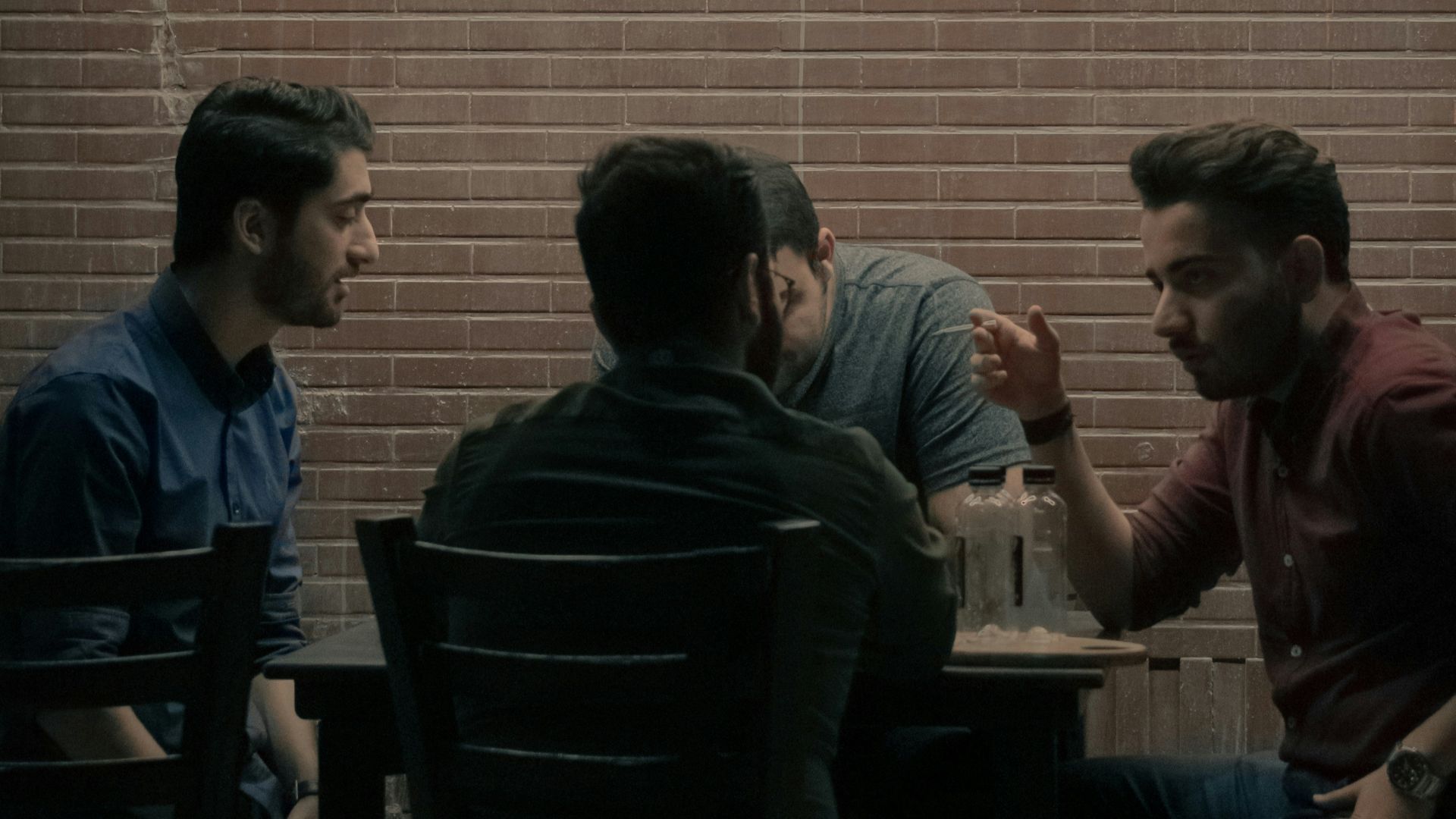 four men sitting beside table