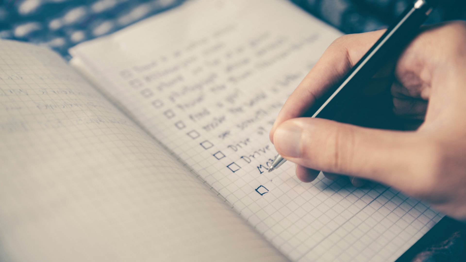 person writing bucket list on book