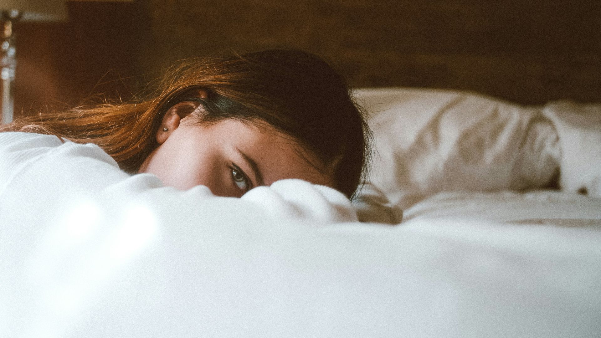 woman resting her head on bed