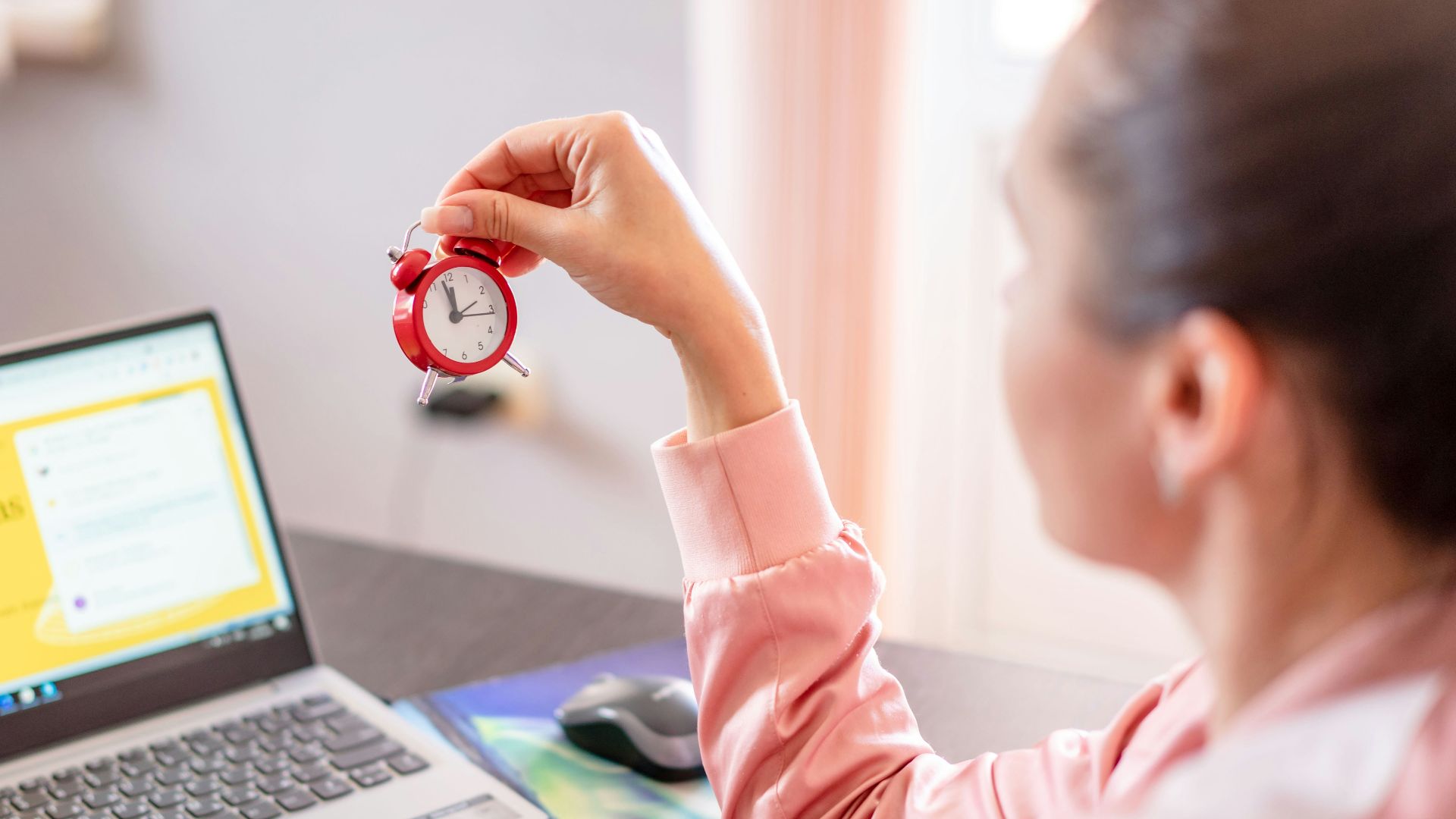 a woman sitting at a desk with a laptop computer
