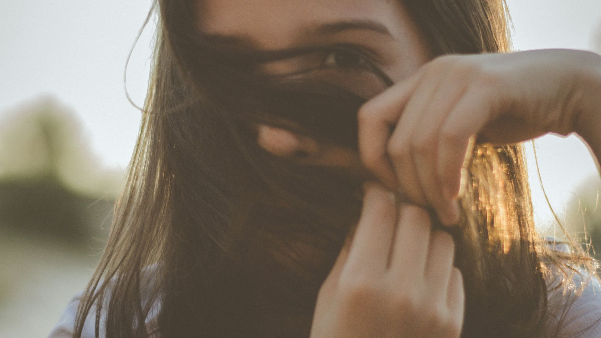 man covering her face with her hair