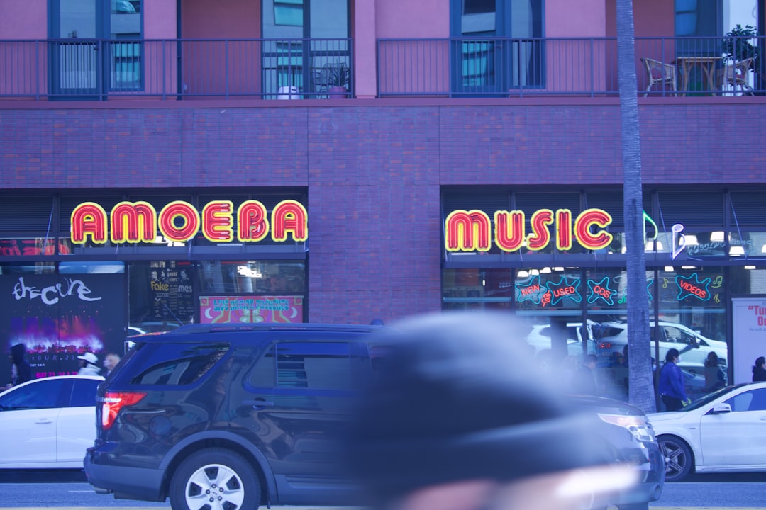 a blurry photo of a car parked in front of a music store