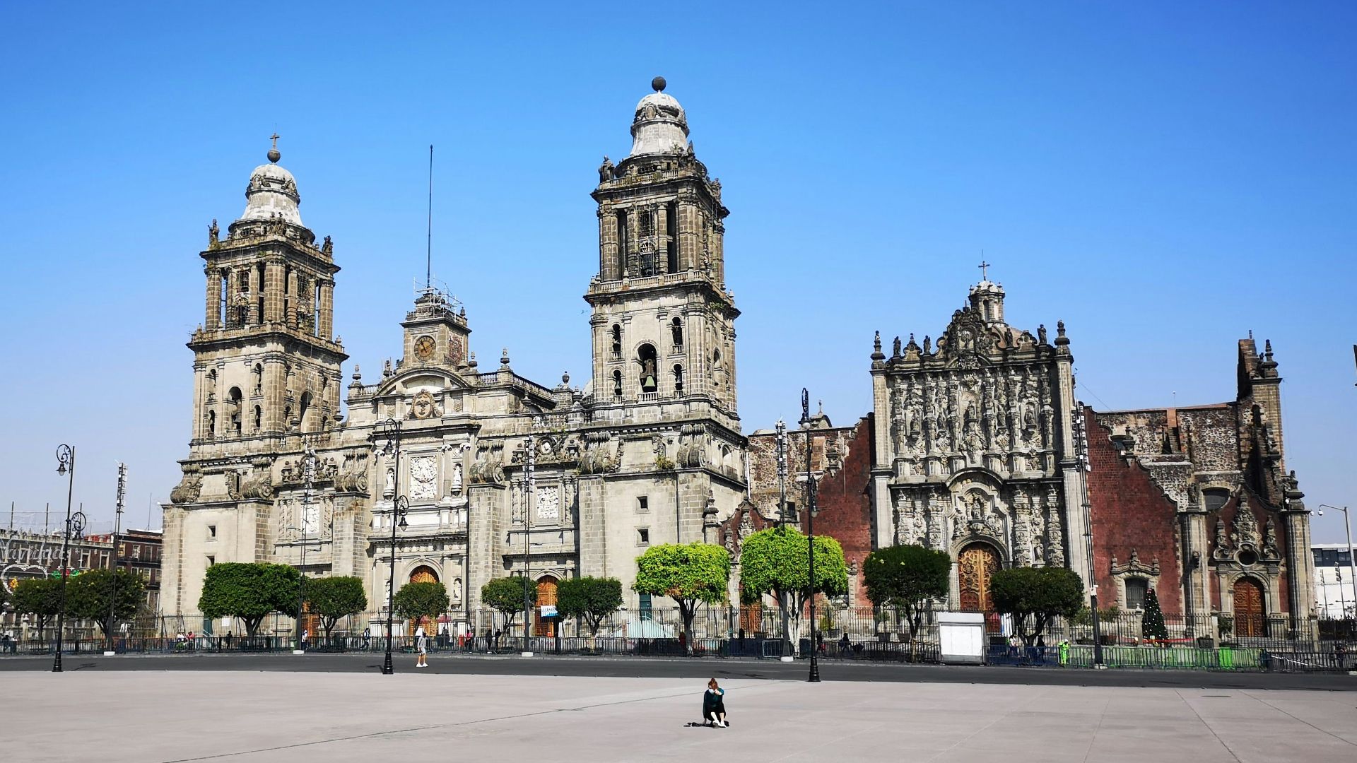 people walking on sidewalk near white concrete building during daytime