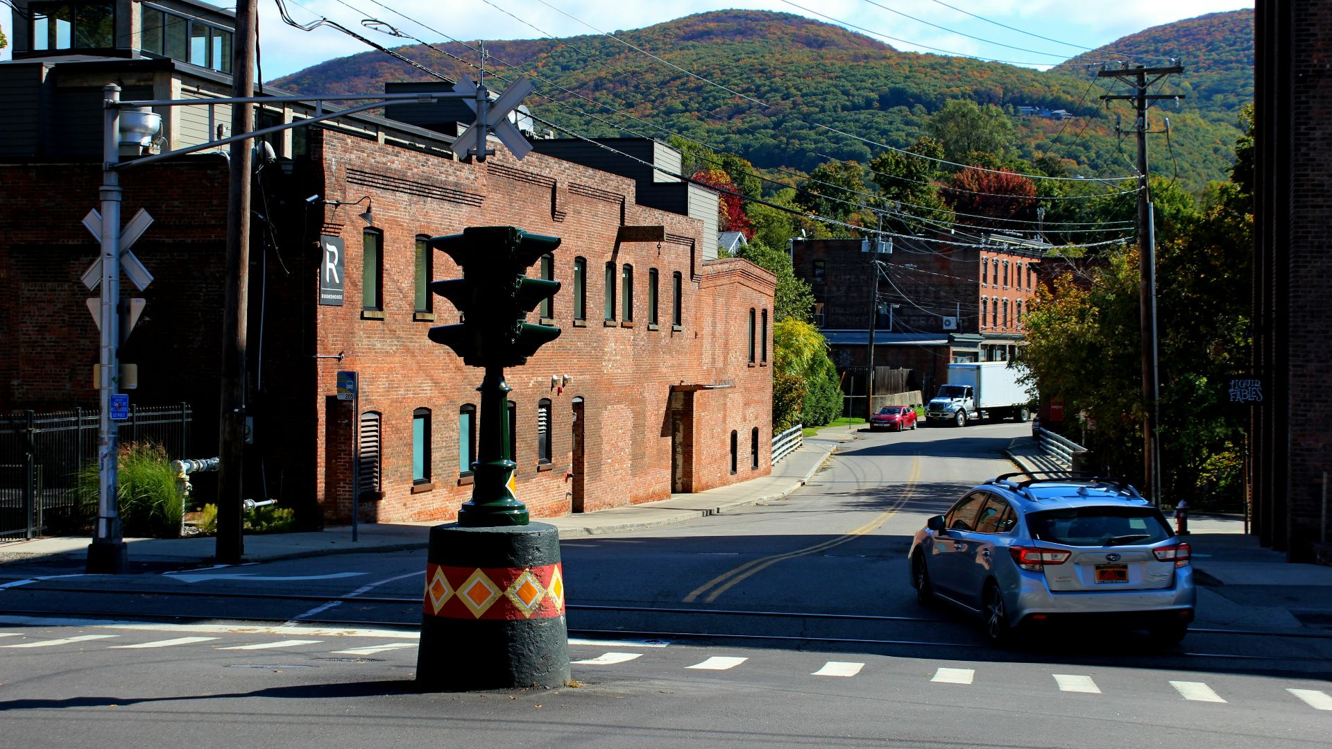 a car driving down a street next to a tall building