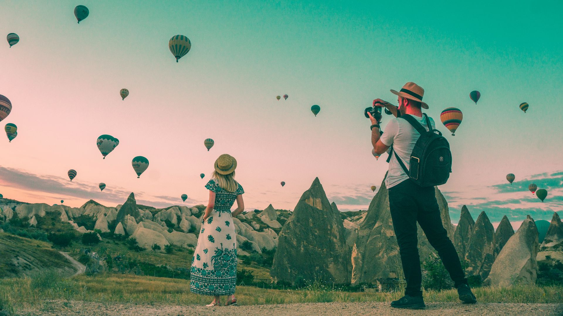 man taking photo of hot air balloons