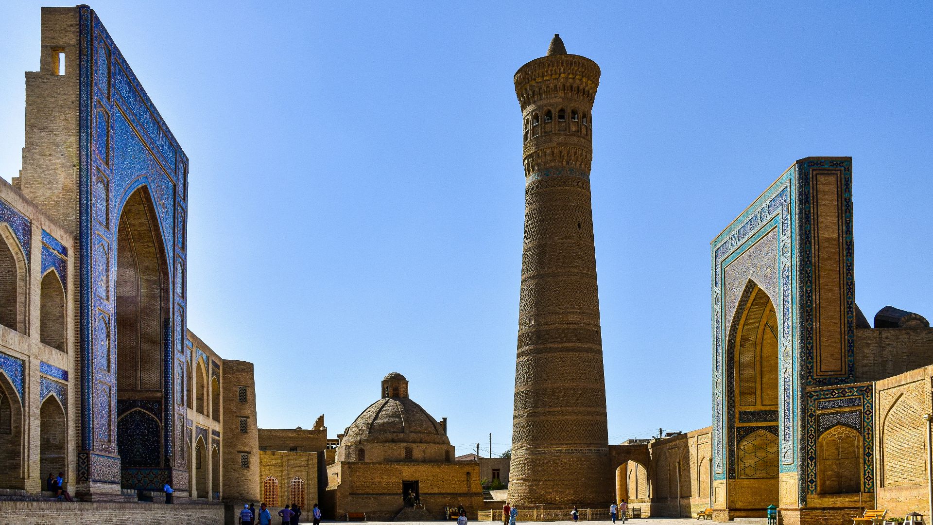 a group of people walking around a large building with towers