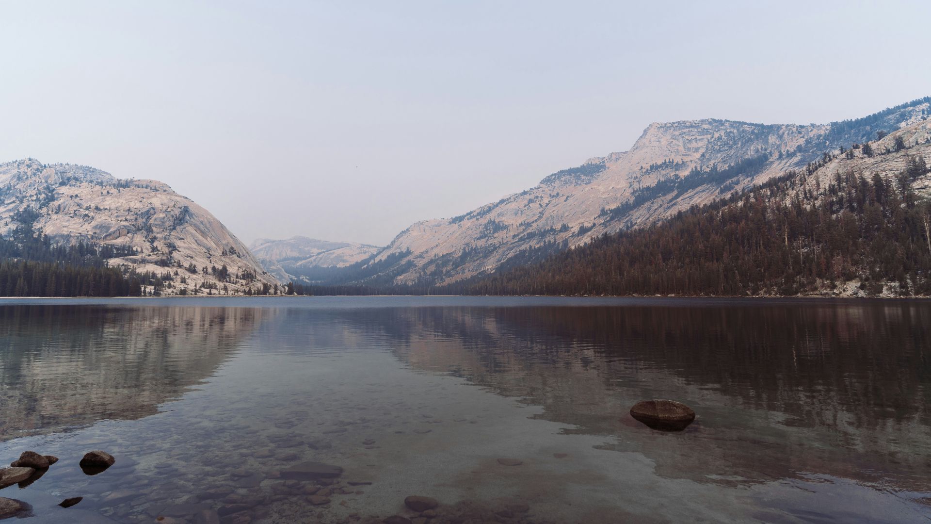 a lake surrounded by snow covered mountains and trees