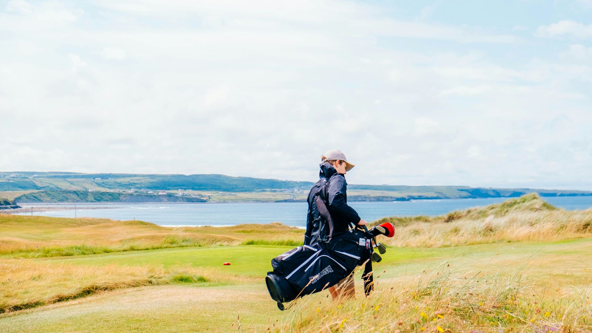 a man walking across a lush green field