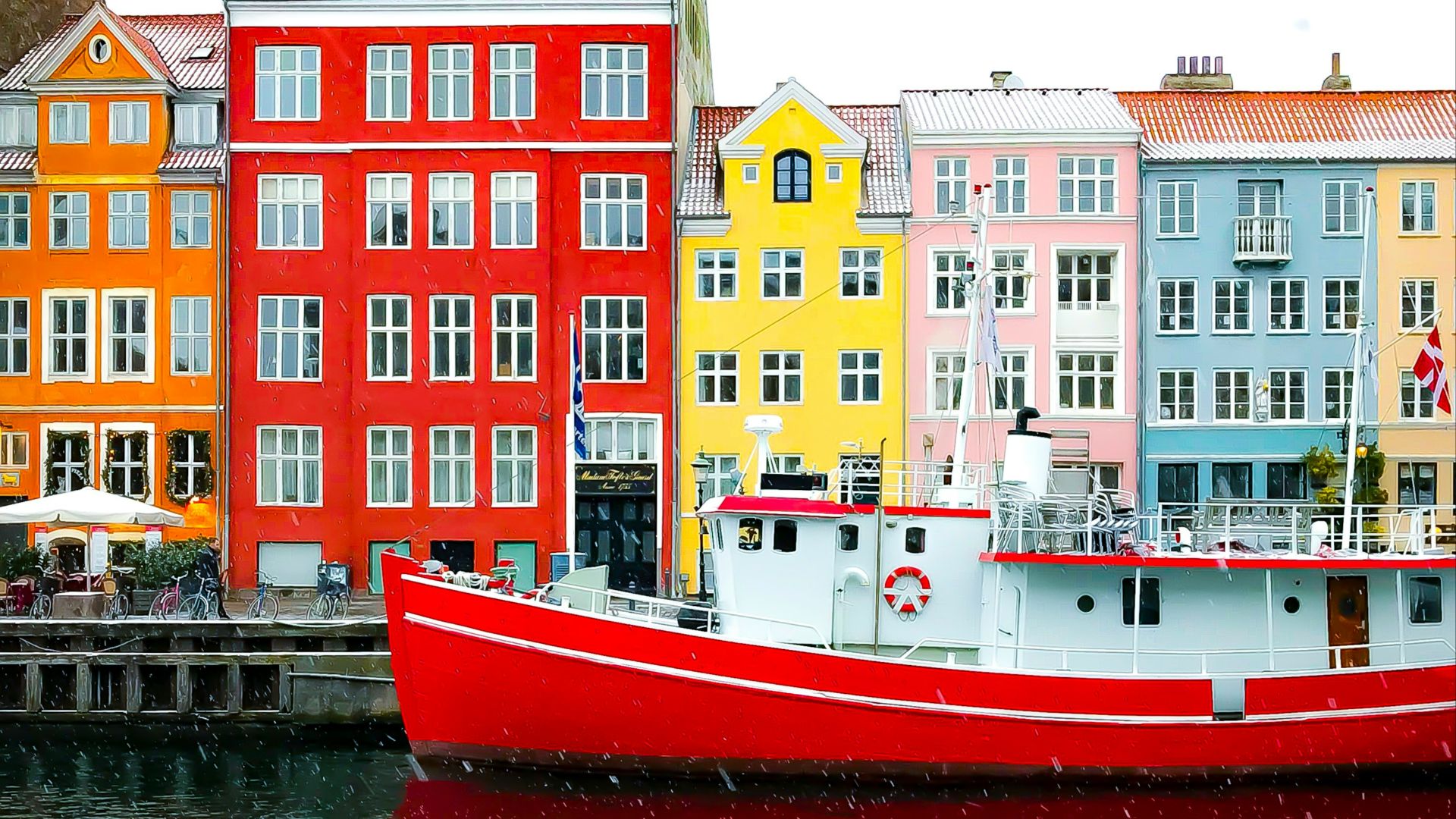 assorted-color buildings near red boat docked on port during daytime
