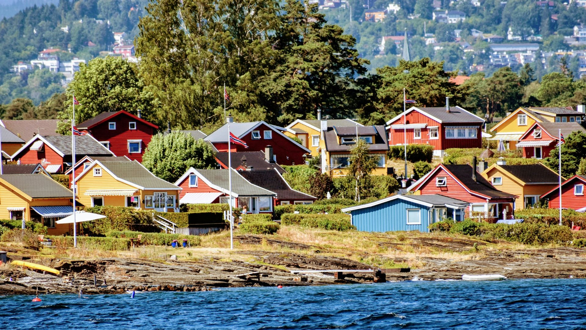 a row of houses sitting on the shore of a lake