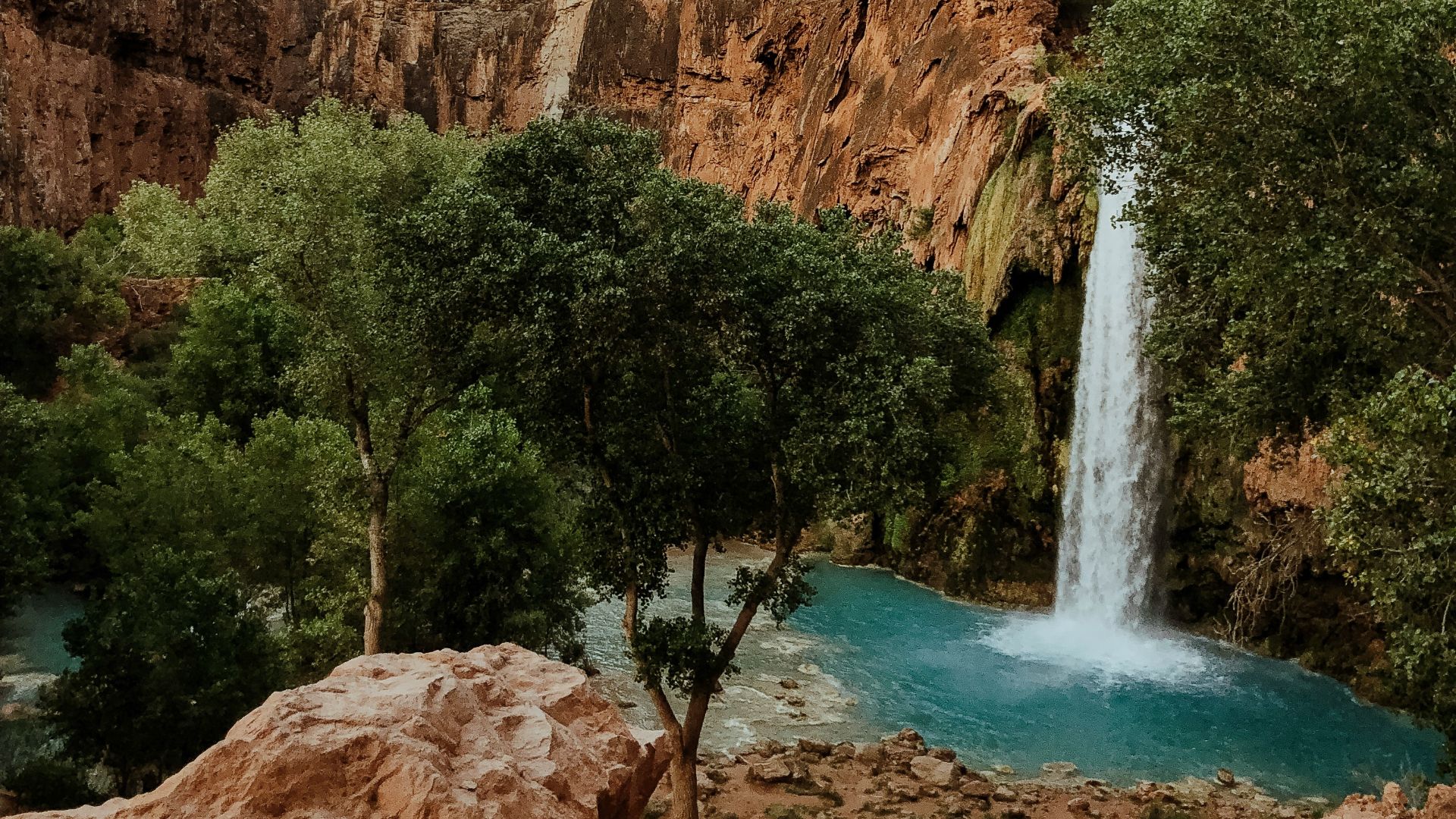 waterfalls in the middle of brown rocky mountains
