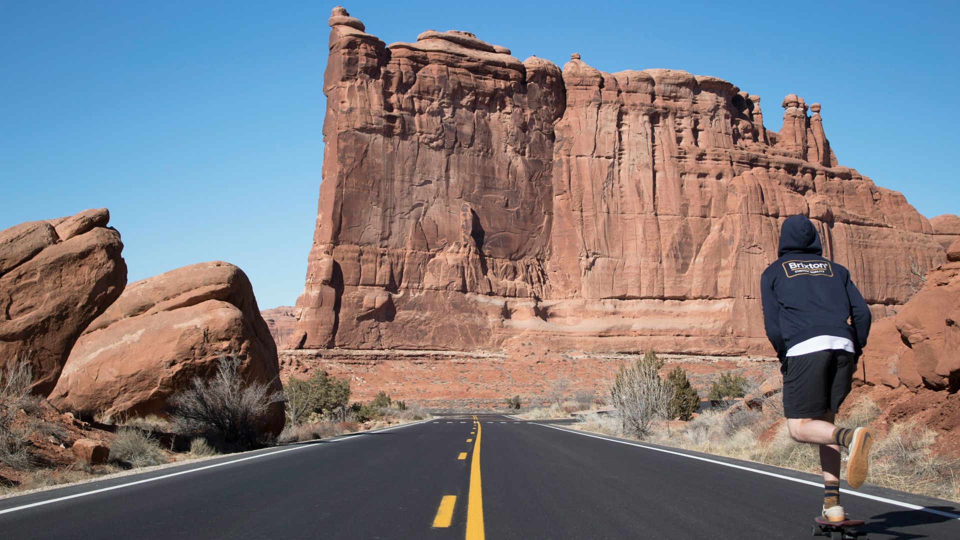 person in blue hoodie skateboarding near ruins