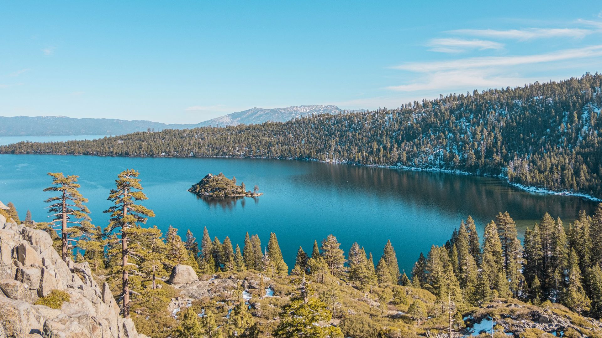 blue lake surrounded by green trees under blue sky during daytime